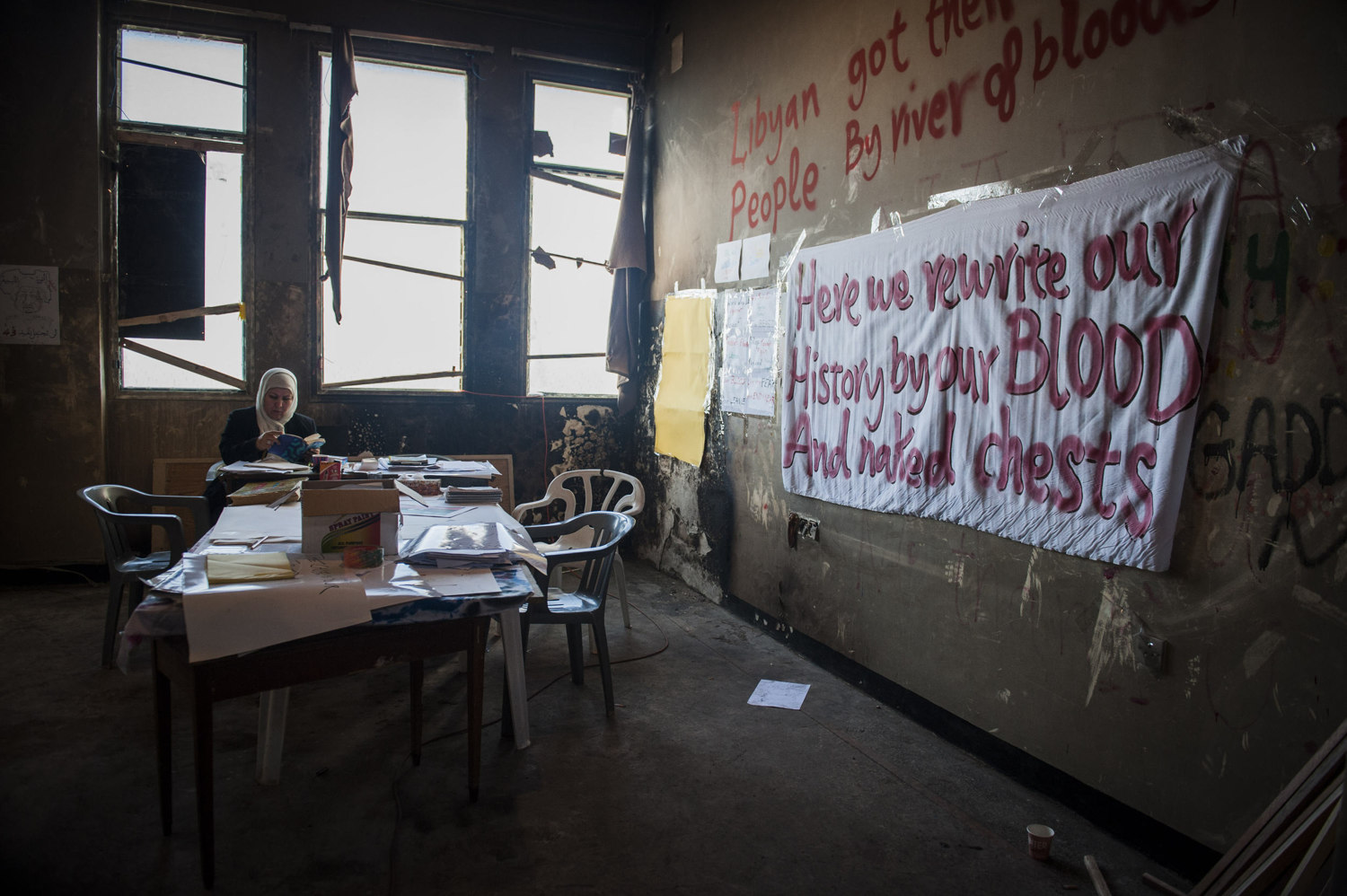  A woman reads a book in a room used to make signs and propaganda in the 17th of February Revolution Media Center. 
