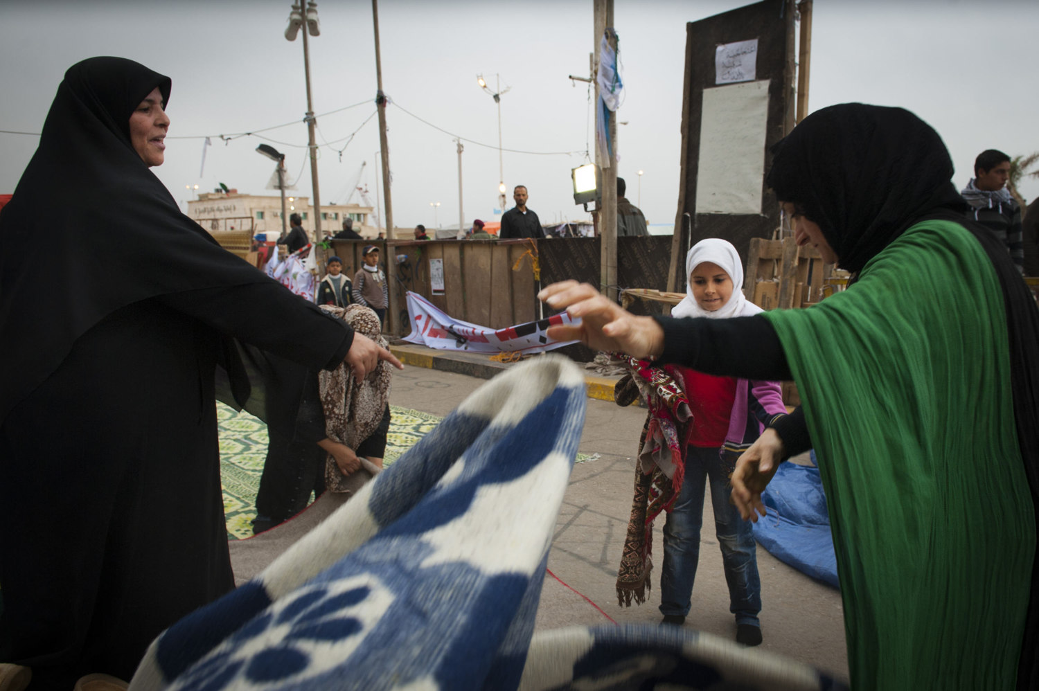  Women setup prayer rugs before Friday Prayers in front of  Benghazi's downtown courthouse, where men and women pray for safety and for the end of Gaddafi's reign. After a violent battle, the resistance members in Benghazi overtook city and set up an