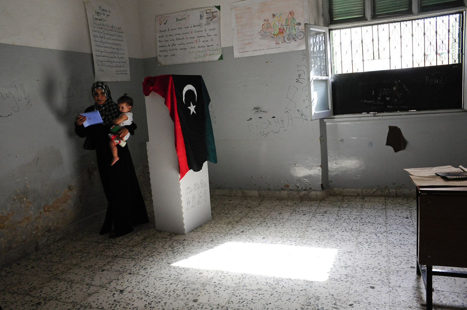  After voting a woman exits the poll with her child at Al Sakina School In Tripoli Libyans go to the polls for the first time in four decades on July 7th 2012. After 42 years of Muammar Gaddafi's reign, Libyans are participating in the first democrat