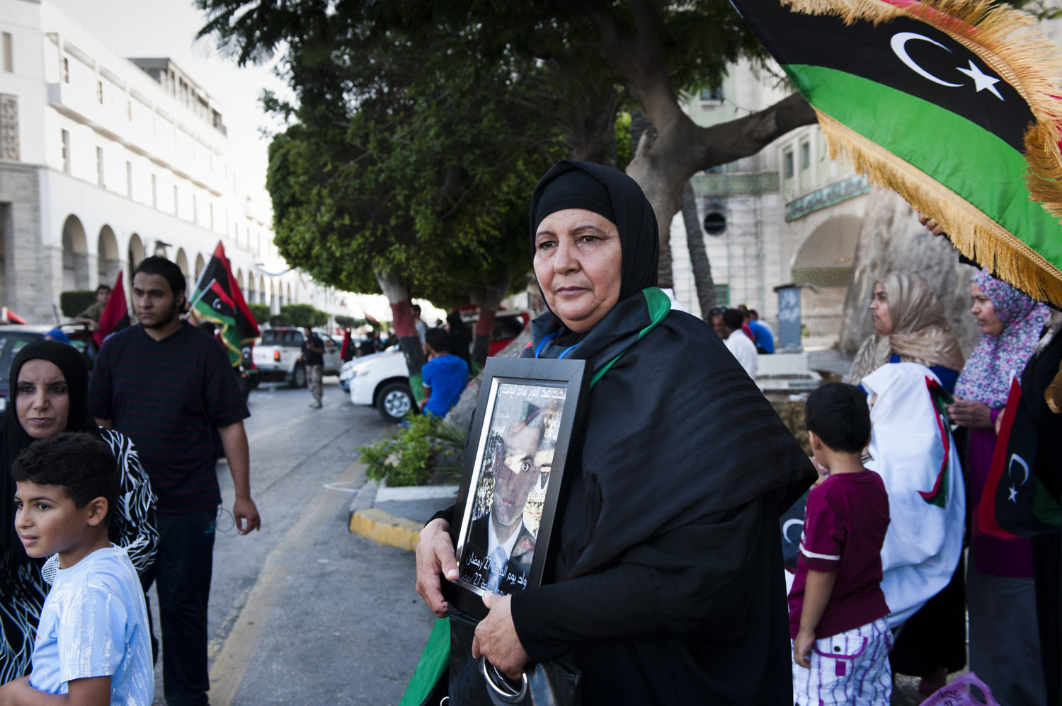  A woman holds a photo of her martyred son in downtown Tripoli as others celebrate the vote. Libyans celebrate after voting.After 42 years of Muammar Gaddafi's reign, Libyans are participating in the first democratic election since 1969. 

 