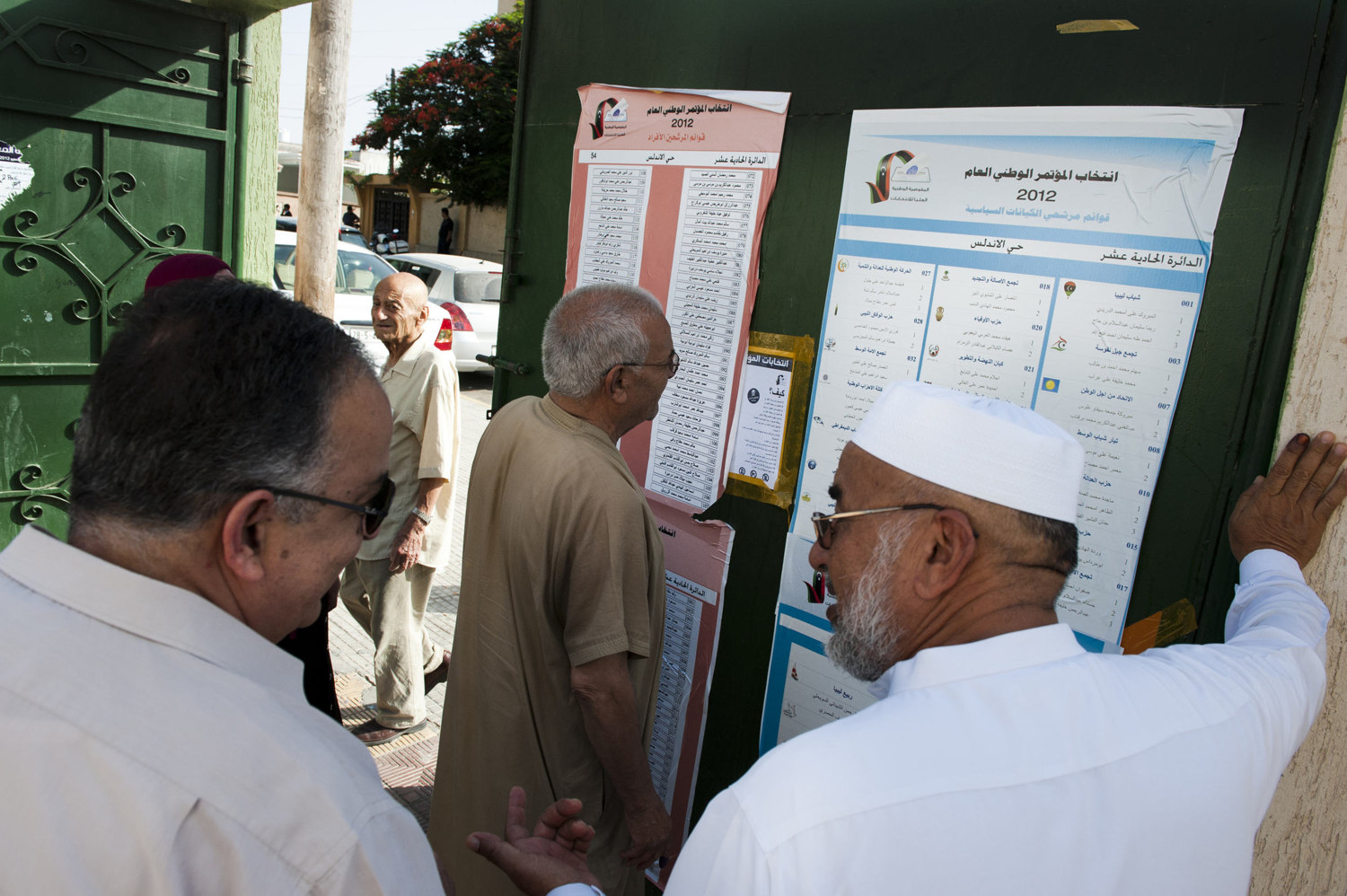  Men debate which polling station to go to. After 42 years of Muammar Gaddafi's reign, Libyans are participating in the first democratic election since 1969. Calls for boycott and election violence threatens the momentous day as campaigning drew to a