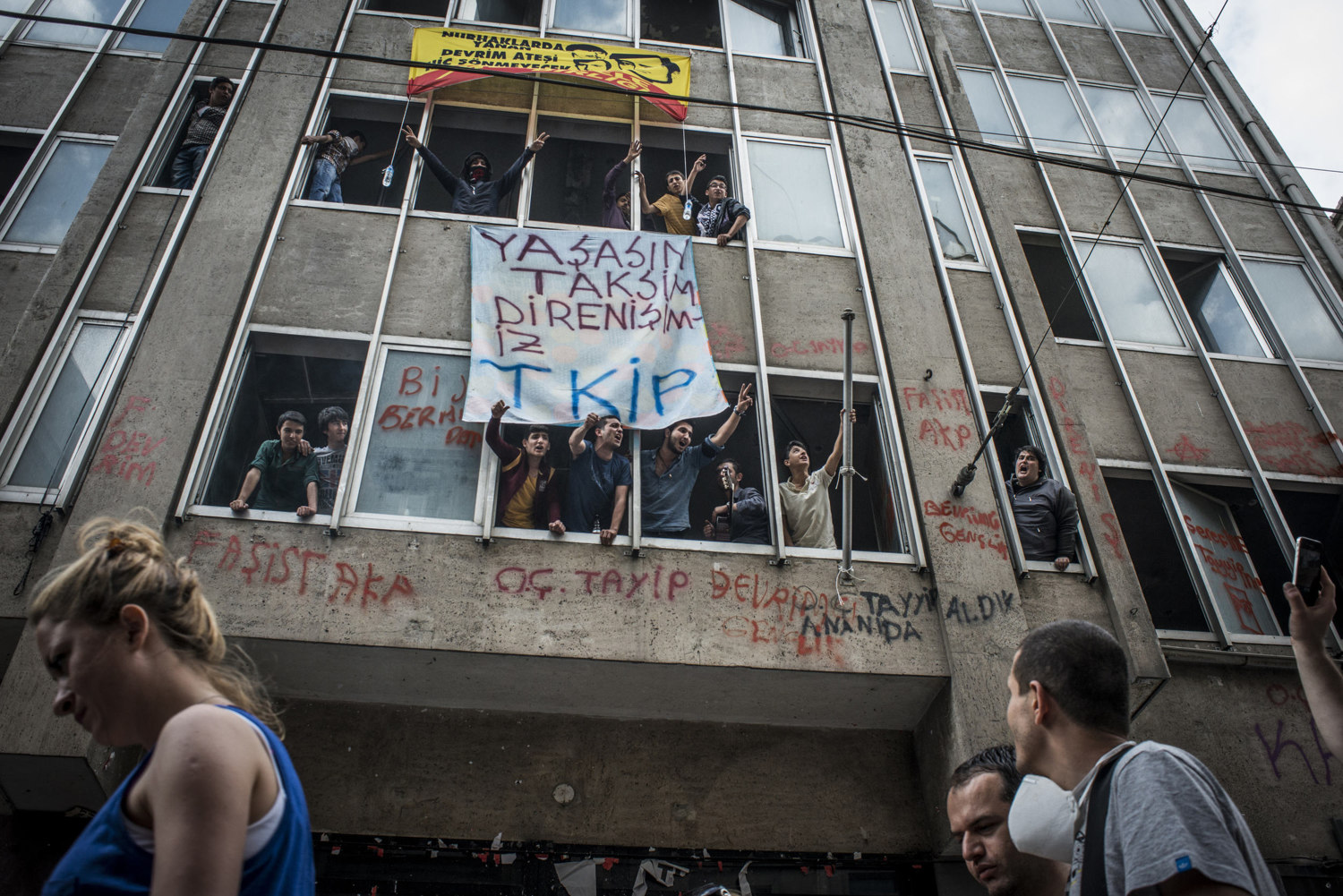  Young men lean out of building chanting against the government on Istikal Cadessi, where yesterdays violent clashes occurred. June 2, 2013. 