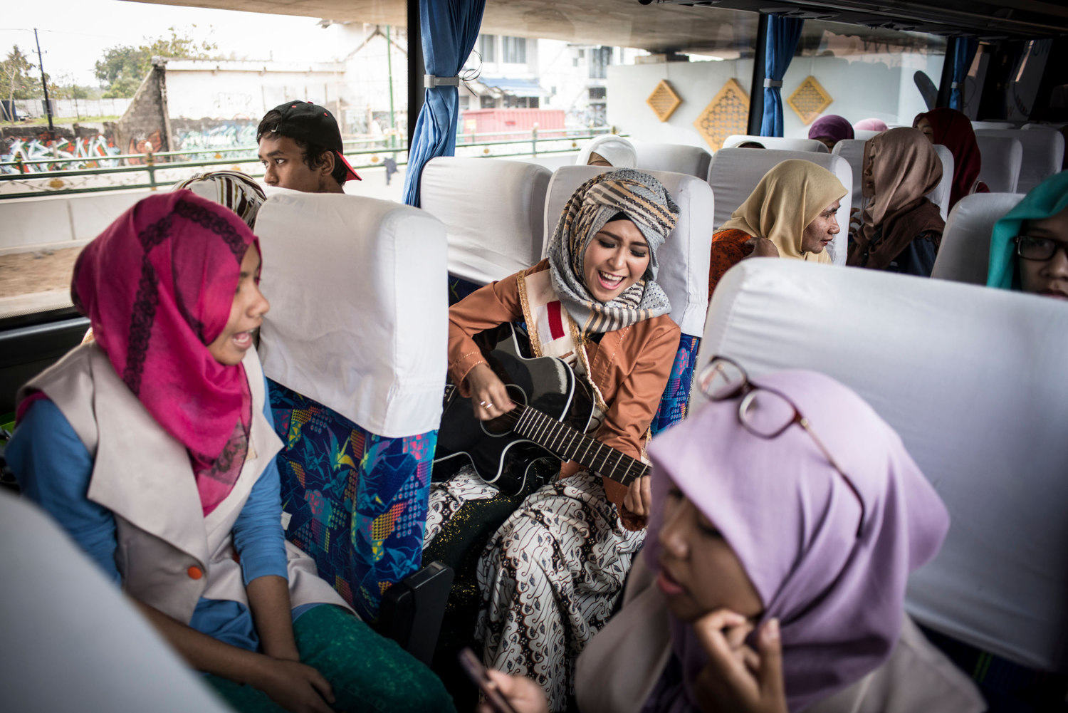  Indonesian finalist Elis Sholihah leads a sing-along on the bus between events.
 