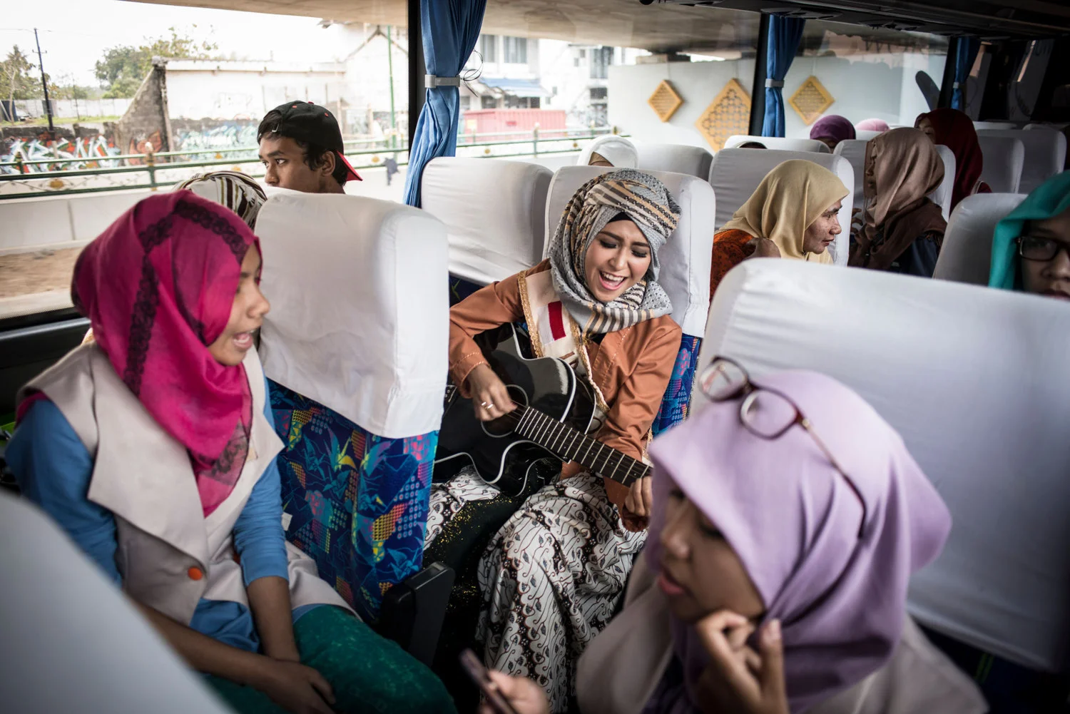  Indonesian finalist Elis Sholihah leads a sing-along on the bus between events.
 