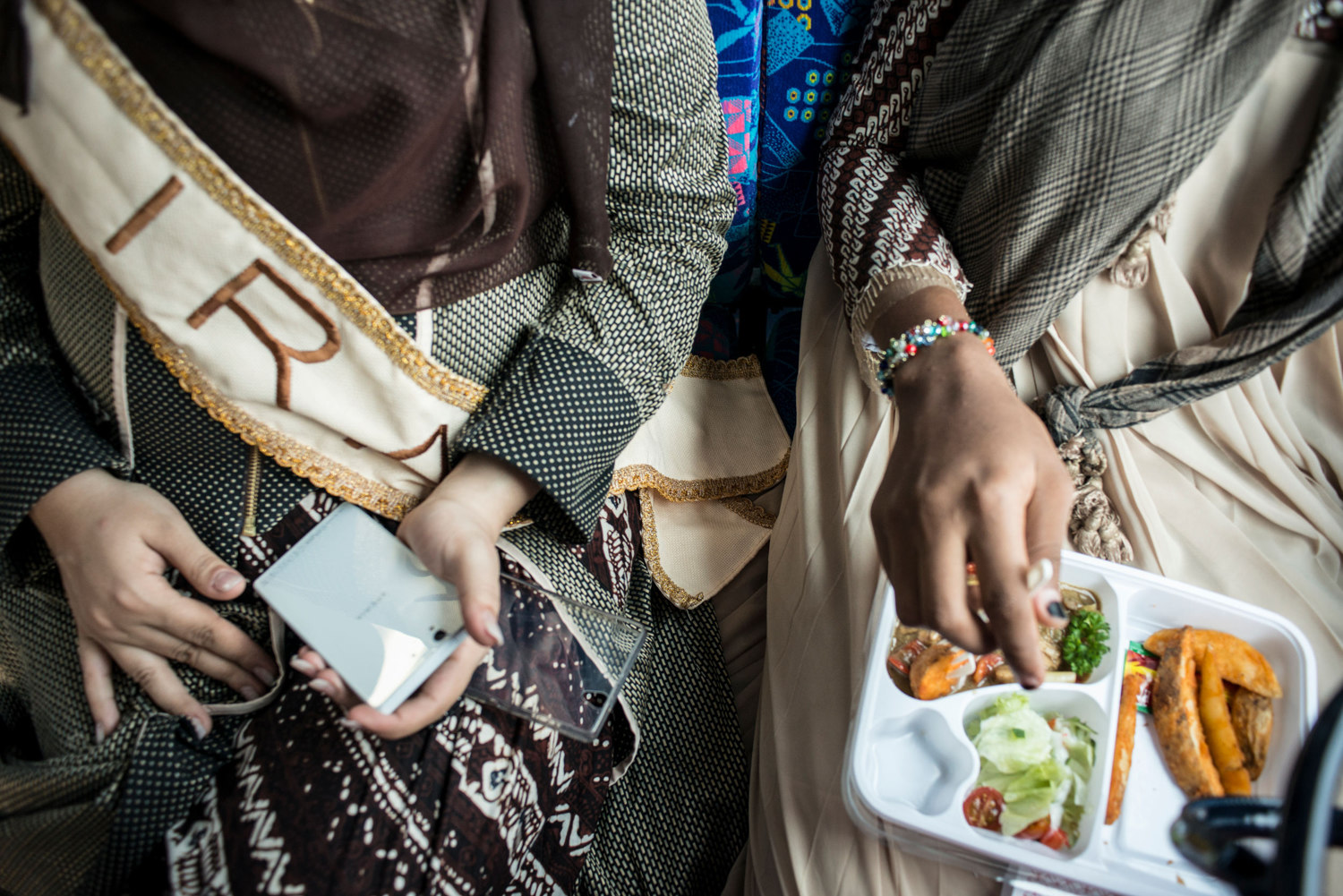  Miss Iran and Miss NIgeria eat lunch on the bus.
 