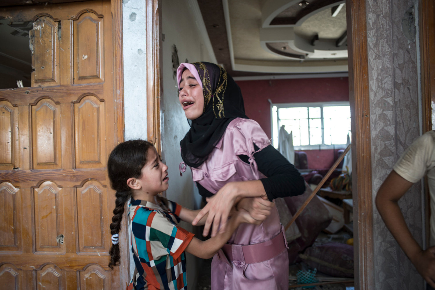  Haneen Harara, 15, and her sister Yasmeen Harara 6 cry upon seeing their family home for the first time. The sisters have lived in this house their whole life and have no where else to go. They are currently living in a UN shelter. 