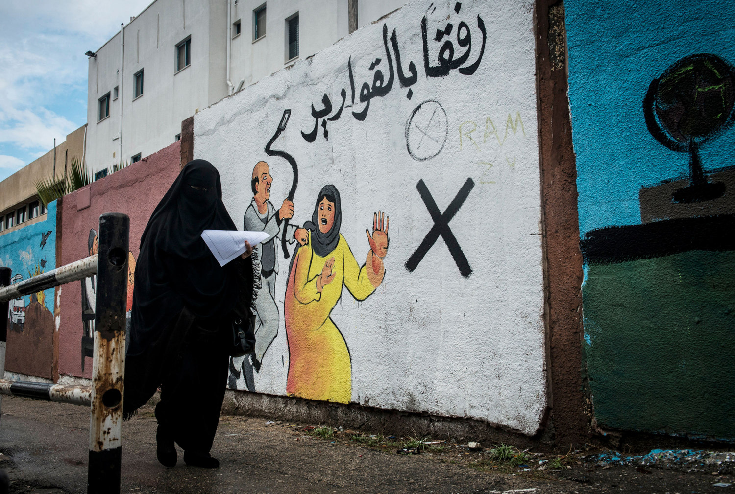  A woman walks by an mural discouraging domestic violence outside if Al-Shifa hospital. According to a 2012 study, some 37% of women are subjected to domestic violence by their husbands. 