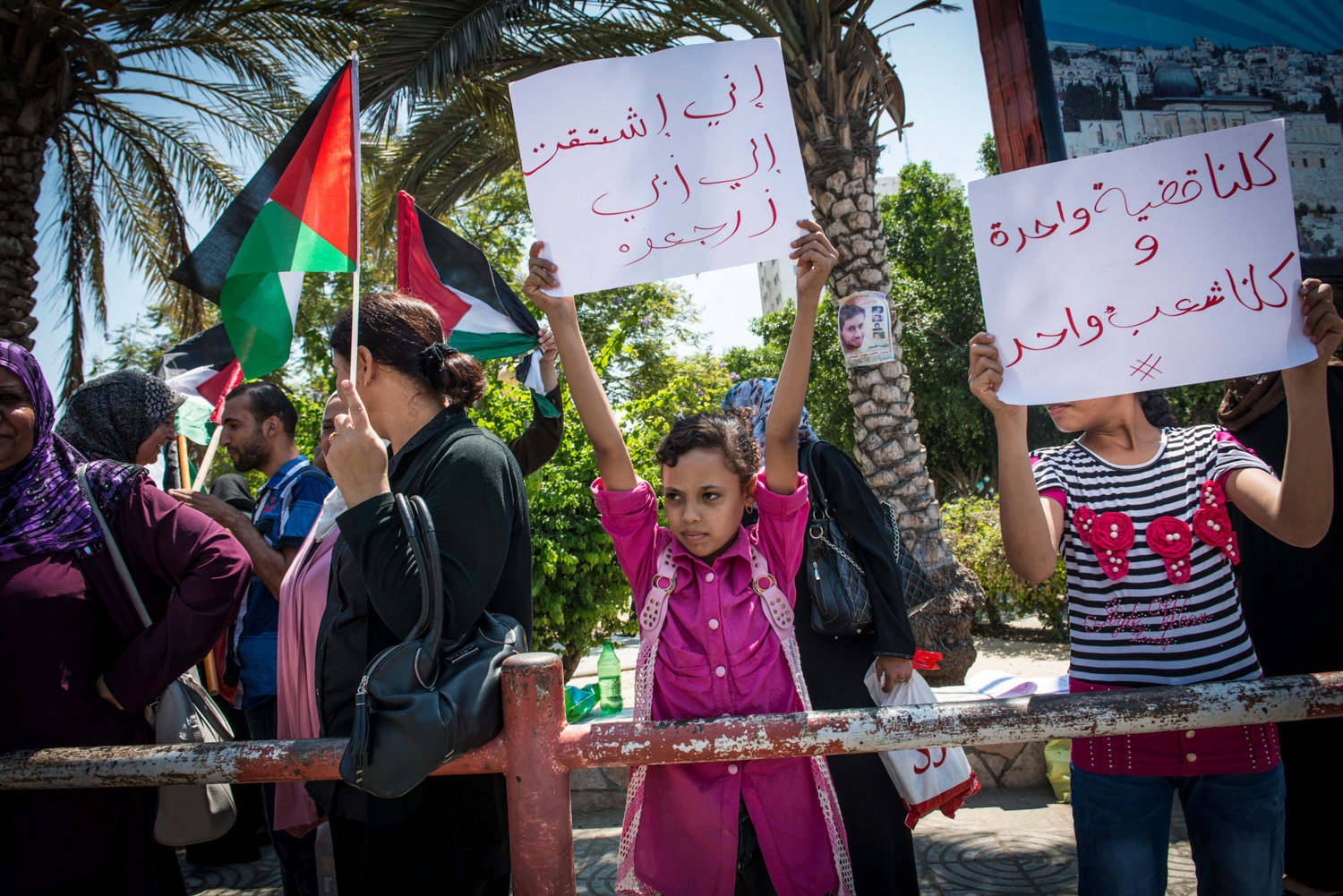  A young girl hold up a sign saying 'I really miss my dad. Bring him back home' at weekly protest for women against the partition of Gaza and the West Bank. 