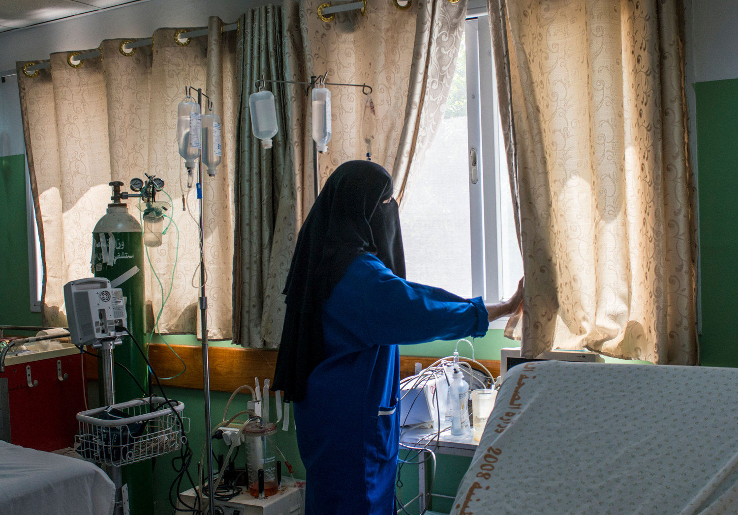  A nurse looks out the window of a hospital in Rafah waiting for more ambulances to bring in corpses after the ground invasion in Gaza. 