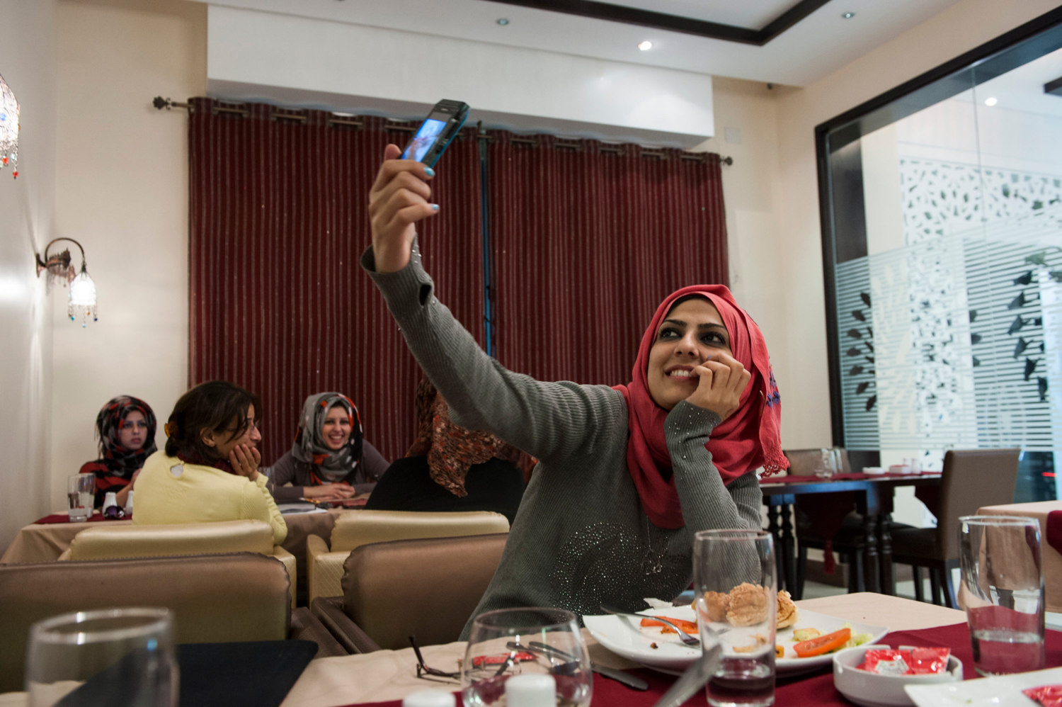  Doaa takes a picture of herself in a trendy cafe in Gaza City. 