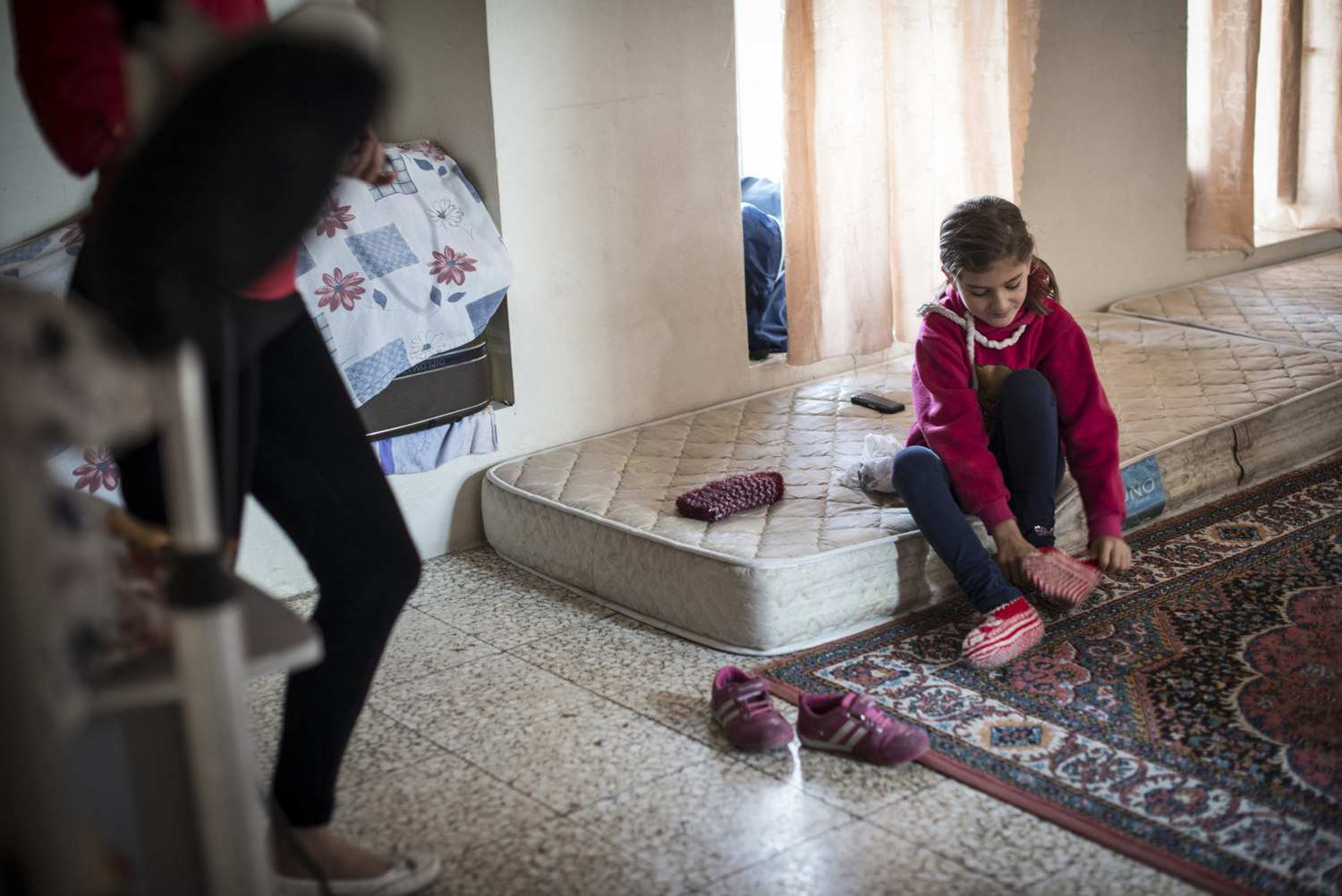  Besme changes her slippers in the bedroom for the family in the Cultural Center on October 30th, 2014 in Midyat, Turkey. 
 