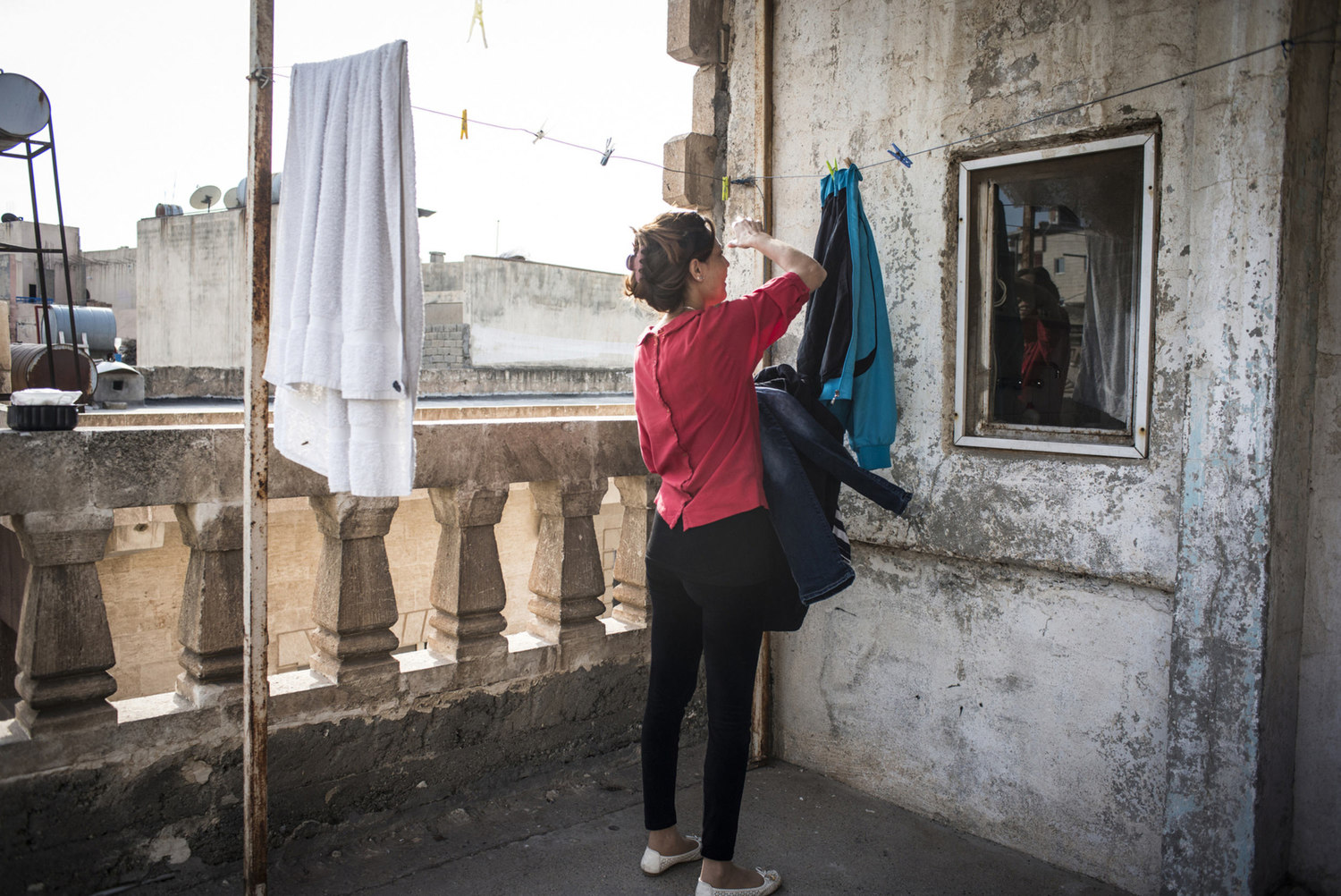  Ninwa Mirza takes in the laundry from outside of her temporary home in the Cultural Center on October 30th, 2014 in Midyat, Turkey. 
 