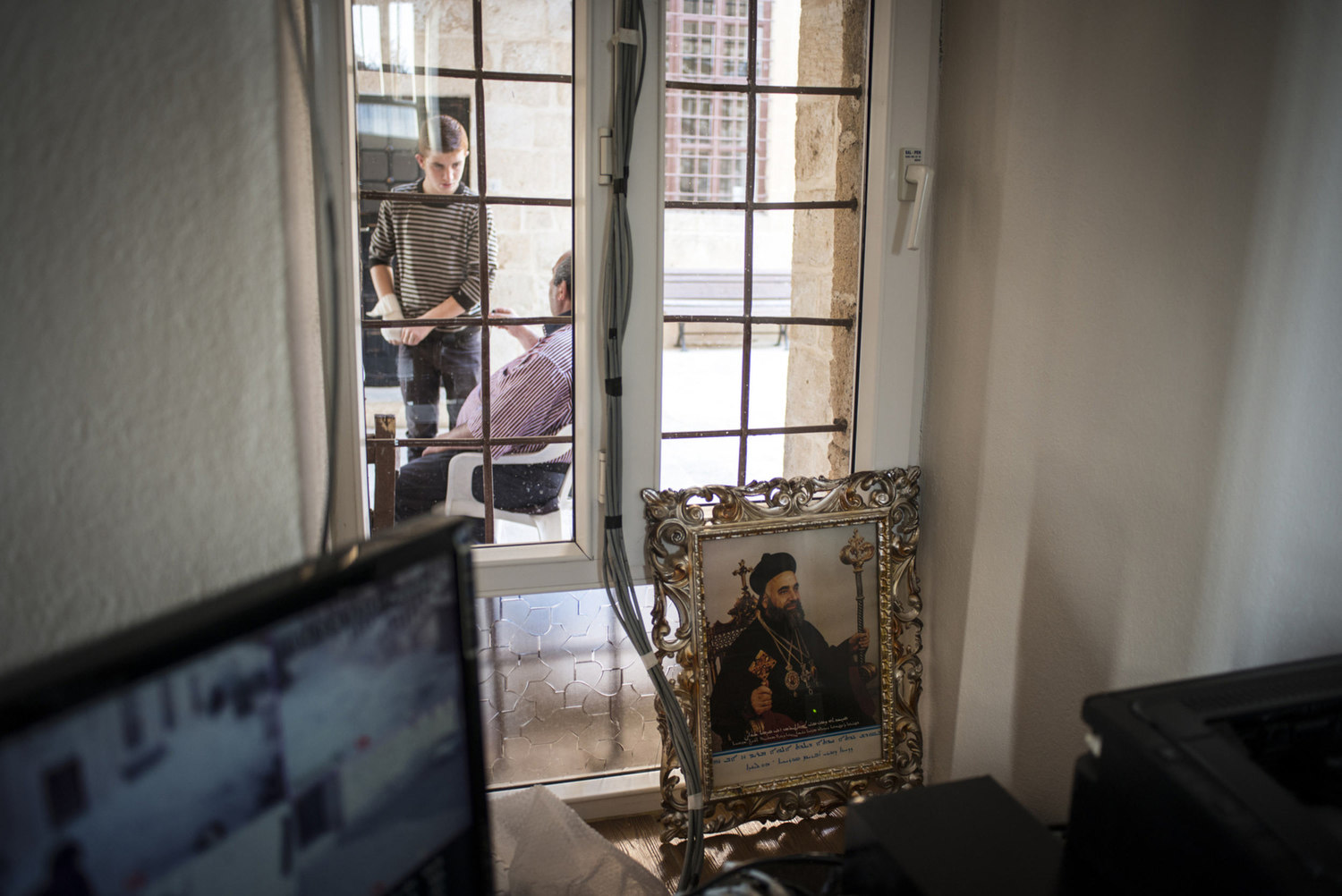  A portrait of a holy figure and CCTV cameras used to monitor the security of the church, where there has been attacks near a window looking out into the courtyard on October 30th, 2014 at Mor Barsaumo church in Midyat, Turkey. 
 