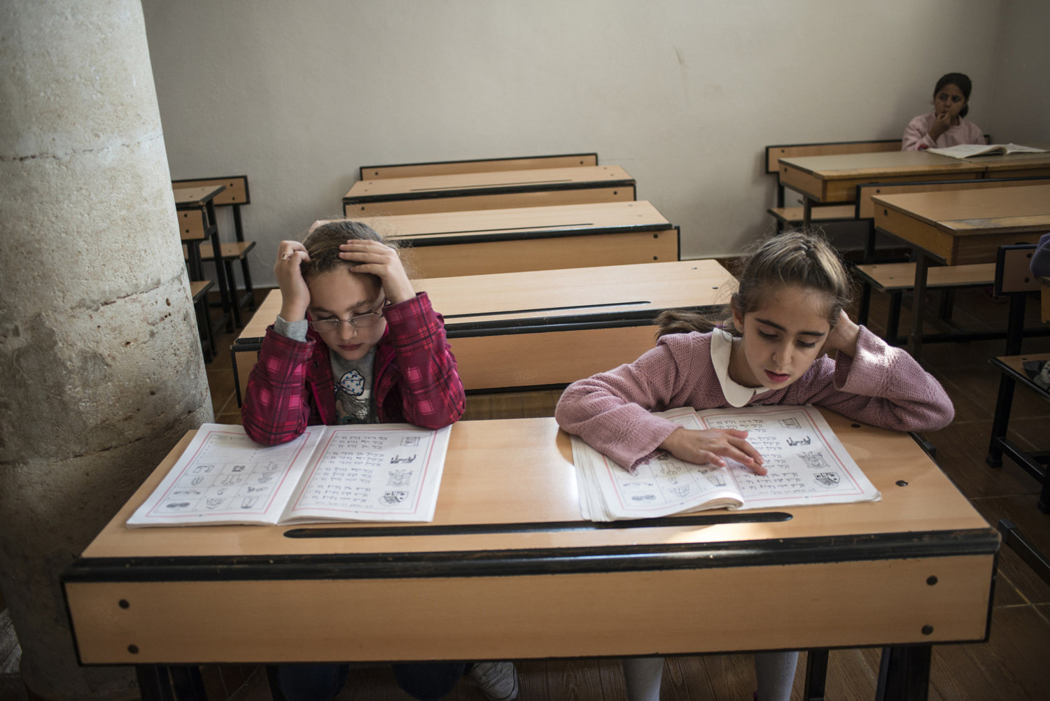  A girl reads during her Assyrian class in the classroom of Mor Barsaumo church on October 30th, 2014.

The Mor Barsaumo church is over 1,500 years old and was renovated in 1943. It is located 21 Şen Caddessi in Midyat, Turkey. 