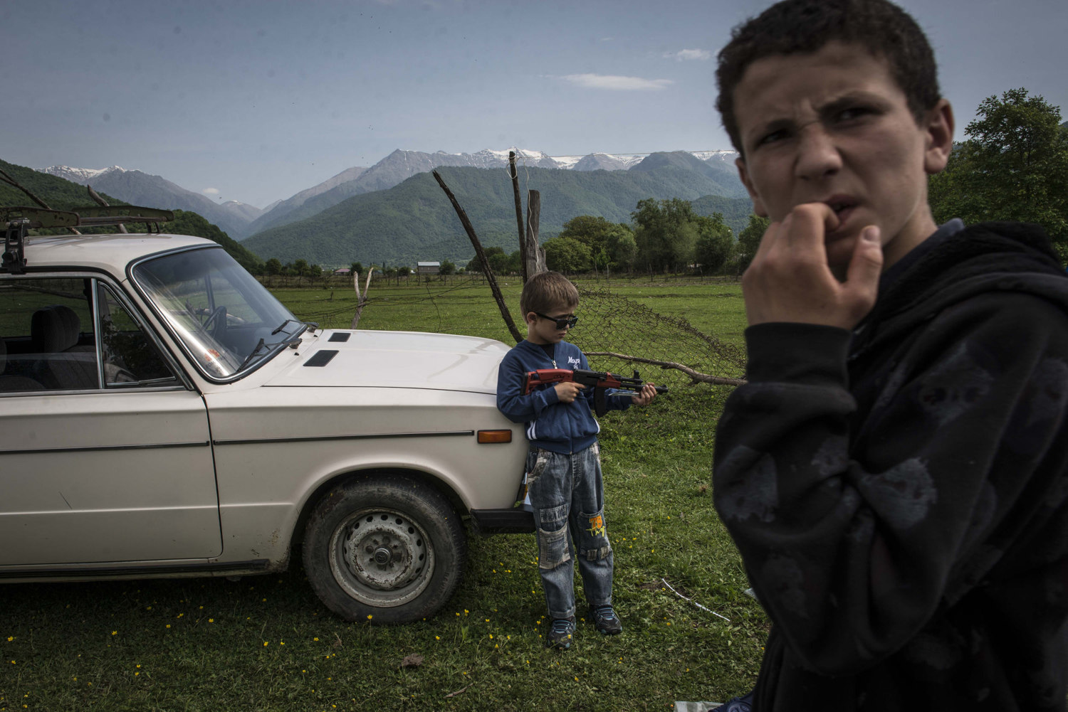  A boy at a festival celebrating WWII victory day plays with a toy gun.

 