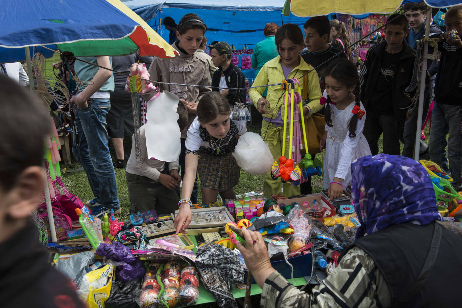  Girls buy trinkets and plastic jewelry at a fair held in honor of Victory Day in Duisi.

 