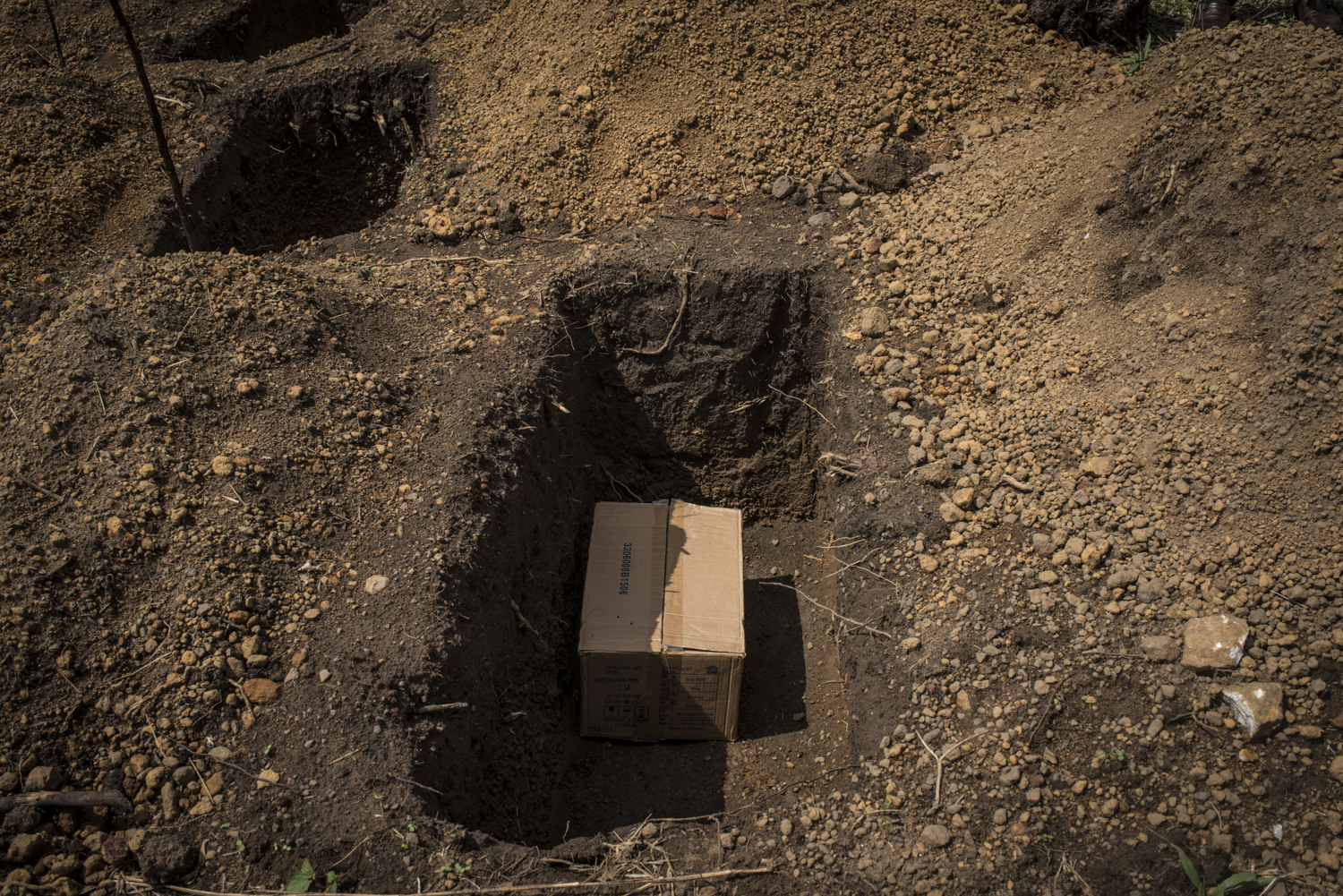  The funeral for Christiana Dasama's baby in Sembuhem cemetery outside of Kenema, Sierra Leone on November 12th, 2015. Traditionally mothers do not attend funerals so the father of the baby Ibrahim Koroma and family friend James "Jimmy" Massaly.  