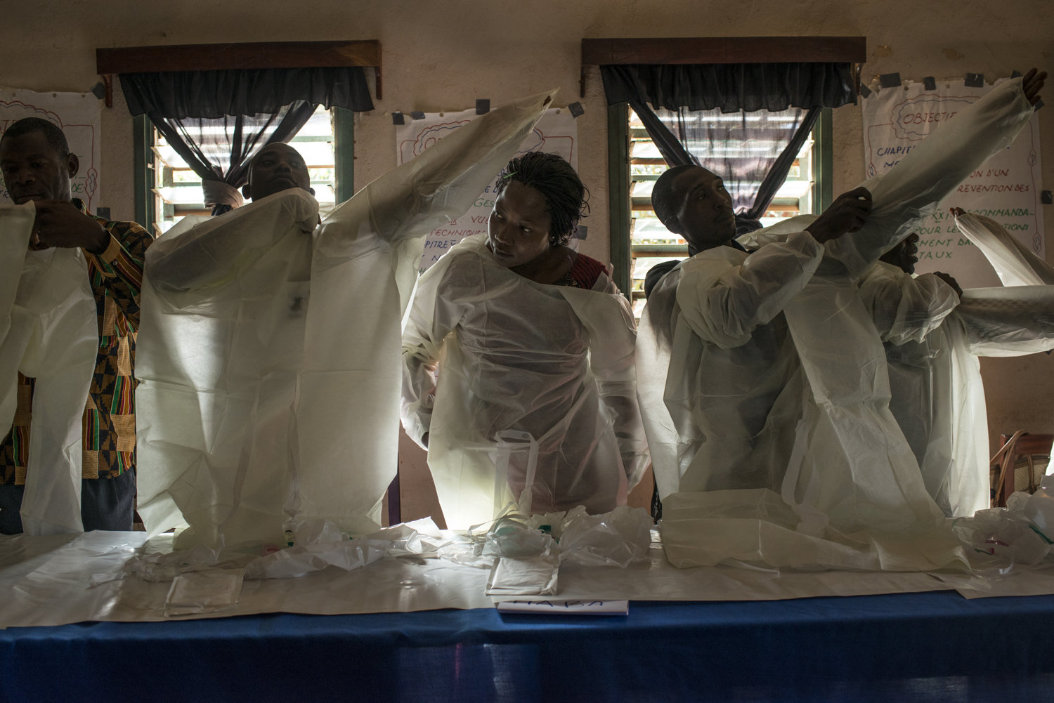  Elisa, center, practices putting on protective gear with her fellow students. Students are handed out protective gear to practice with on Day 2 of the JHIPAGO training. This session is led by Mrs Saran Kaba-in Faranah, Guinea on November 17th, 2015.