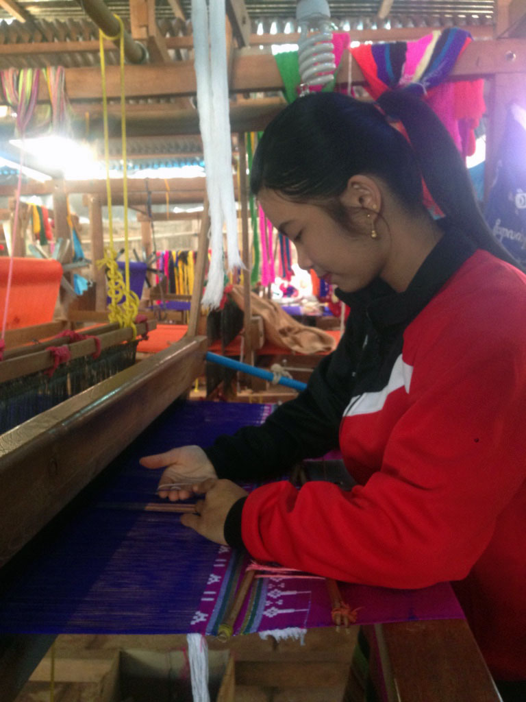 Nang Hom Khay on the Foot Pedal Loom. A Pedal Loom is an artisanal weaving method that uses the artisans feet to alternately lift and lower the thread.