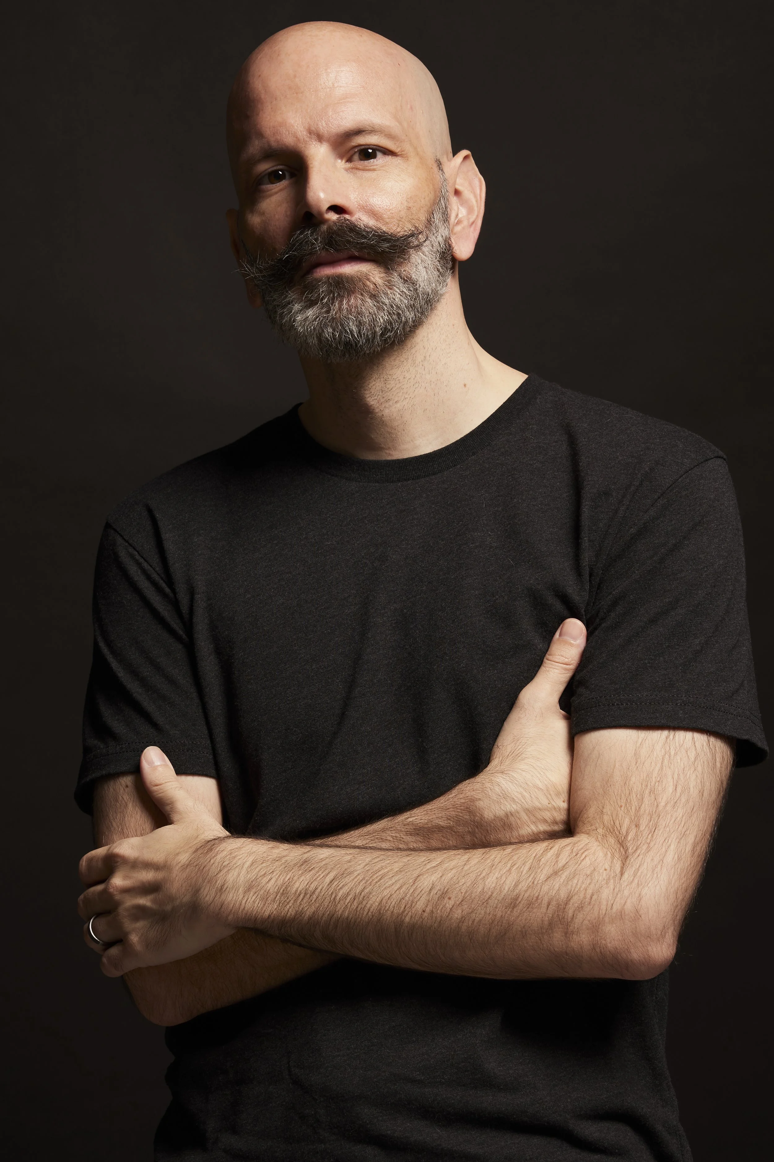 Photo of Steve Molter in a black t-shirt with his arms crossed.