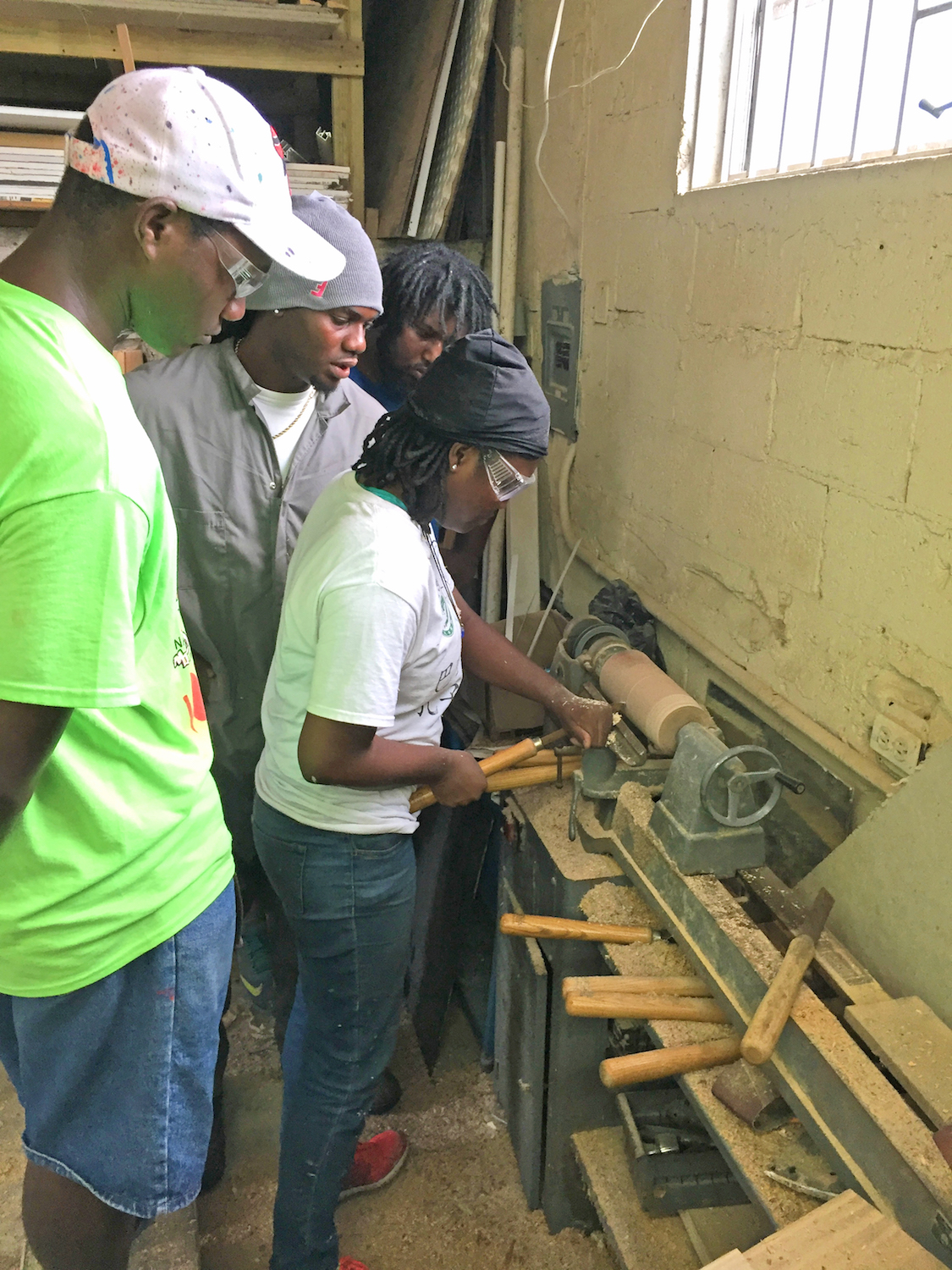 Carpenter Fritz Cox working alongside students Jarrette Stubbs, Cordeia Munnings, and Matthew Rahming on UB’s Oakes Field campus. (Photo by Keisha Oliver)
