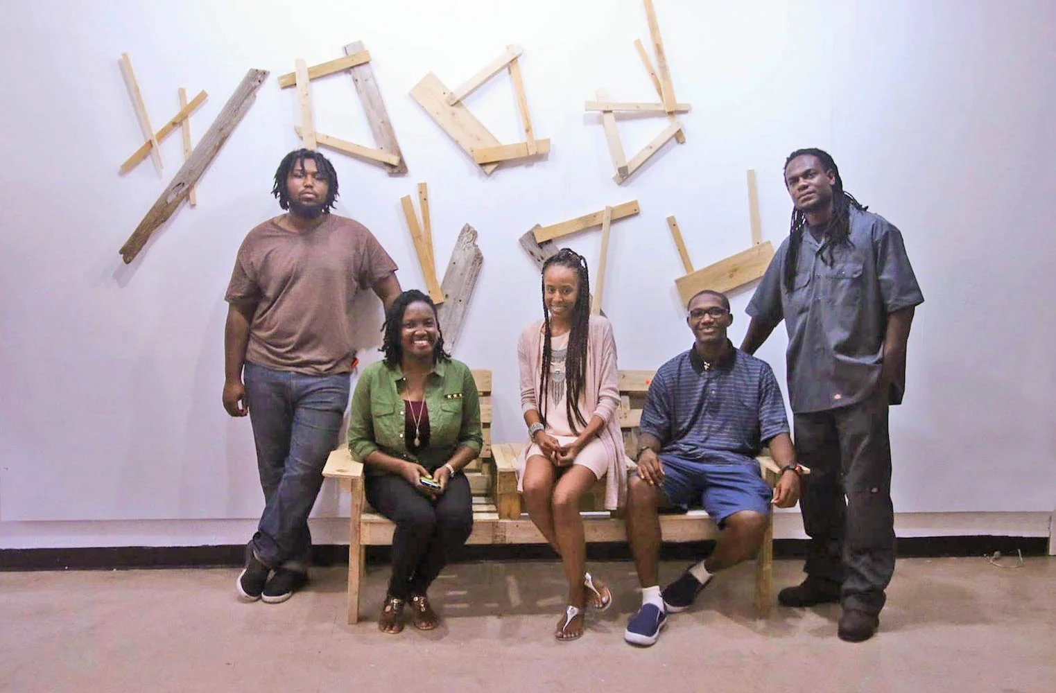 Exhibitors of "Wood You" in front of exhibition signage. 