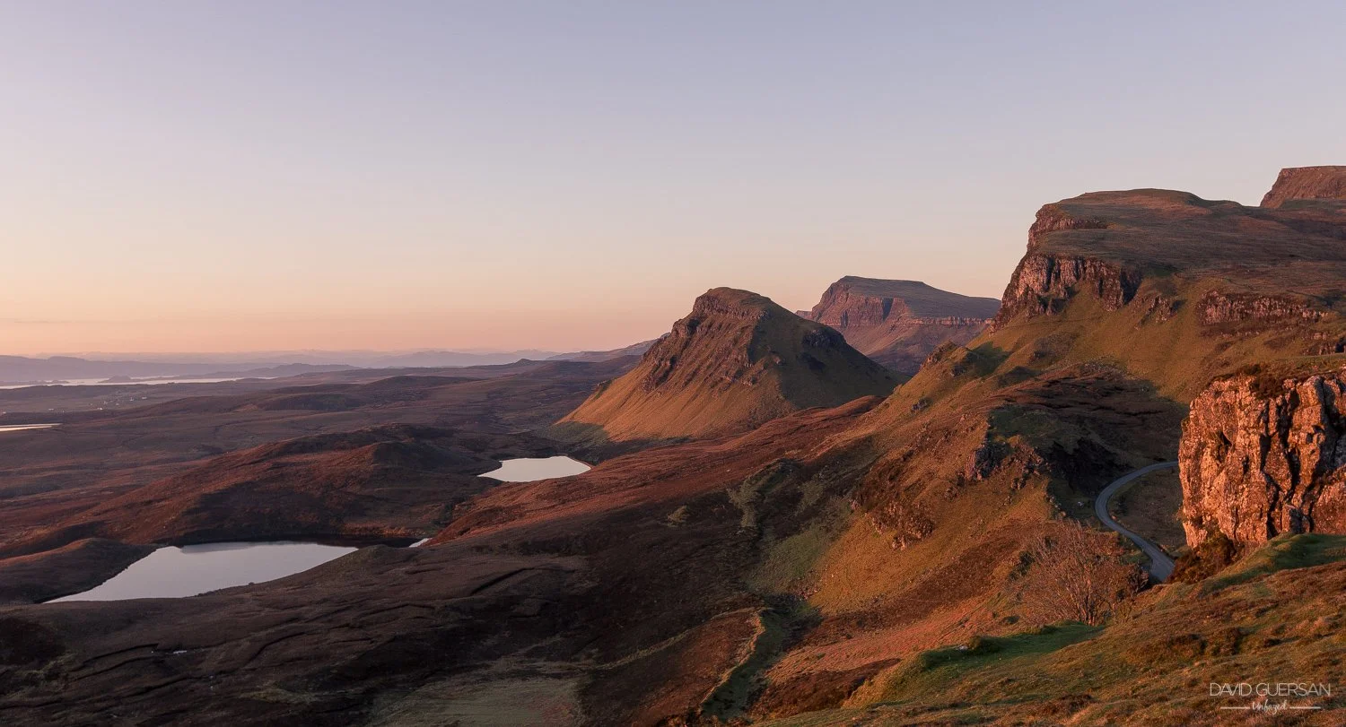Paysage de montagnes et de lacs au coucher du soleil avec un ciel clair et une route sinueuse
