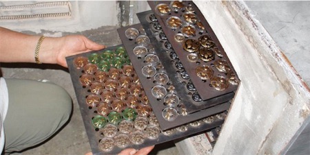 After finish, trays of buttons are returned for one final intense heating to fire-polish and seal the work. 