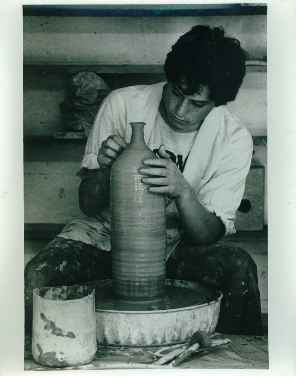 A young, clay-spattered Jonathan at the potter's wheel.