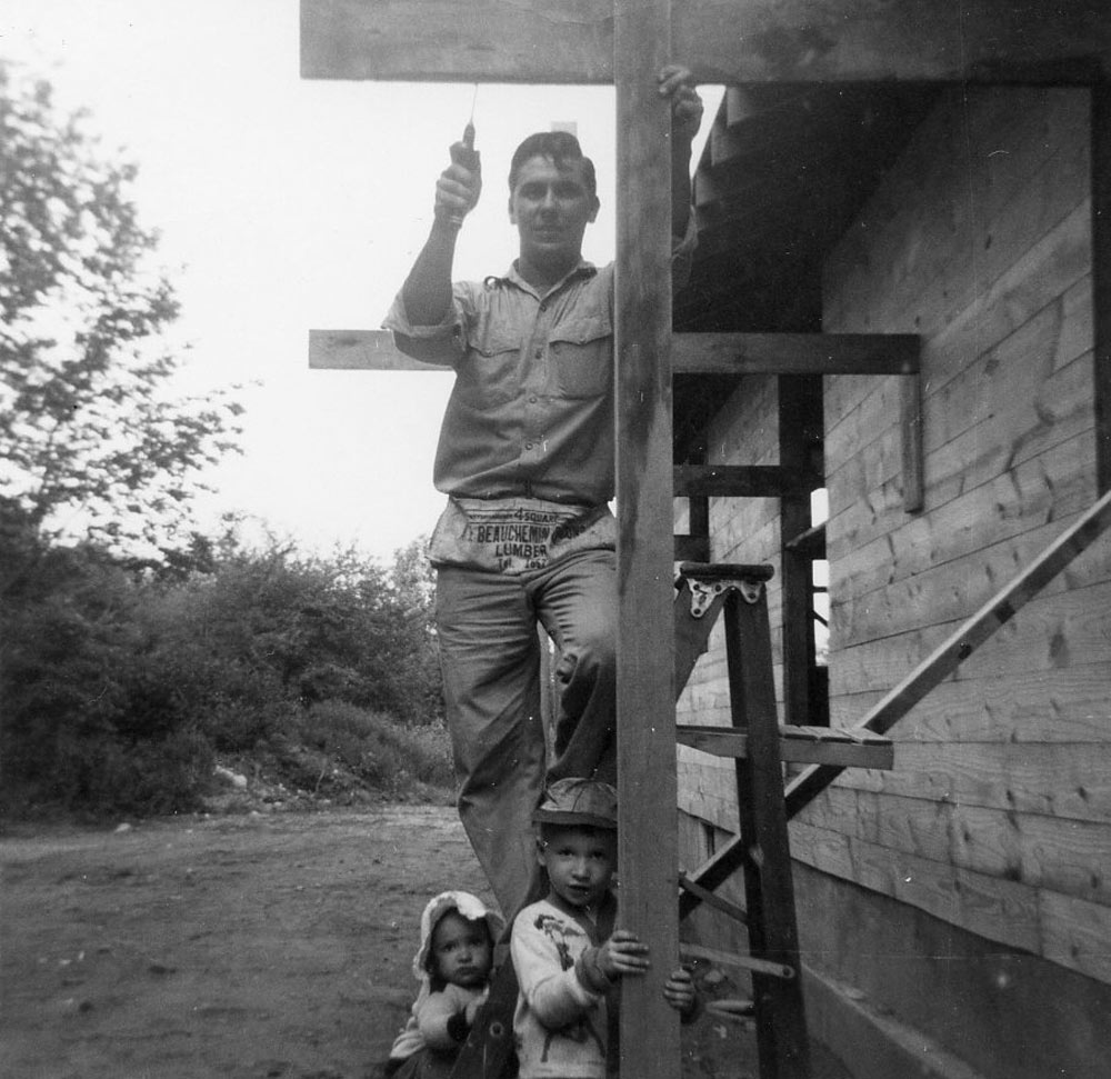 Young Norm and his sister helping their dad, who built the house they grew up in.