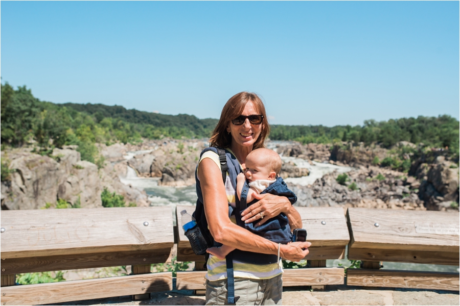 Allie's Mother wearing on of the twins on the front and a backpack on the back at Great Falls.