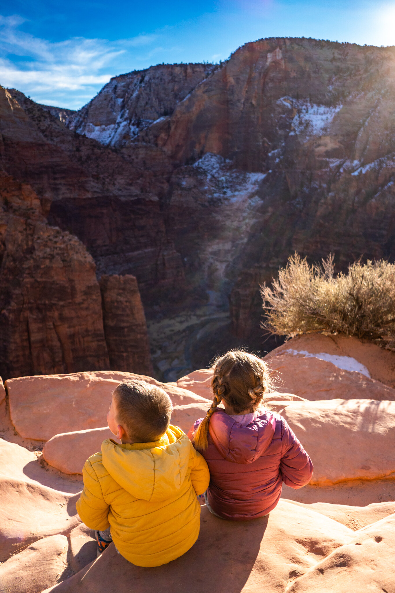 The kids sitting overlooking scout lookout which is the entry point to angels landing