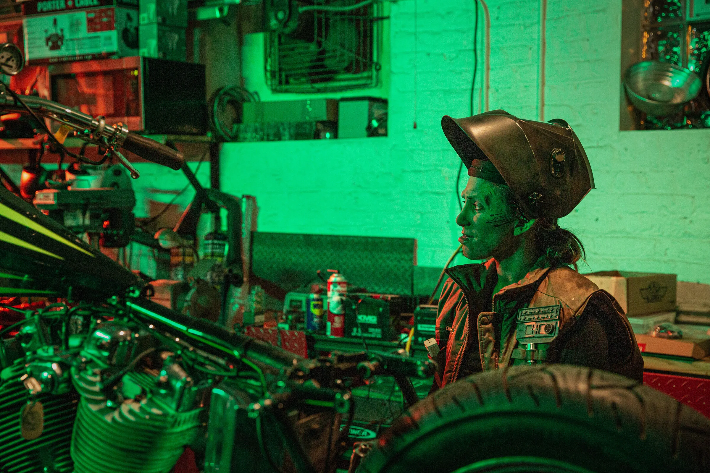  On set Unit still of actor Jennifer Baker in a motorcycle repair shop. Photo ©Courtney Rader 