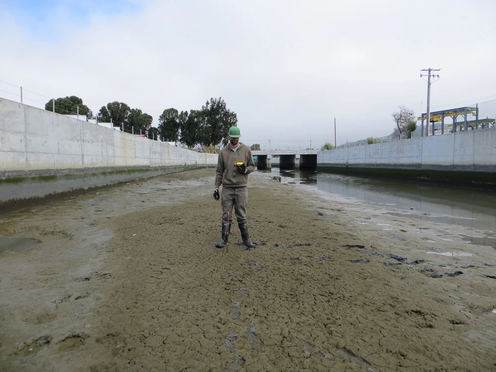 Measuring sediment depth in the flood control channel.