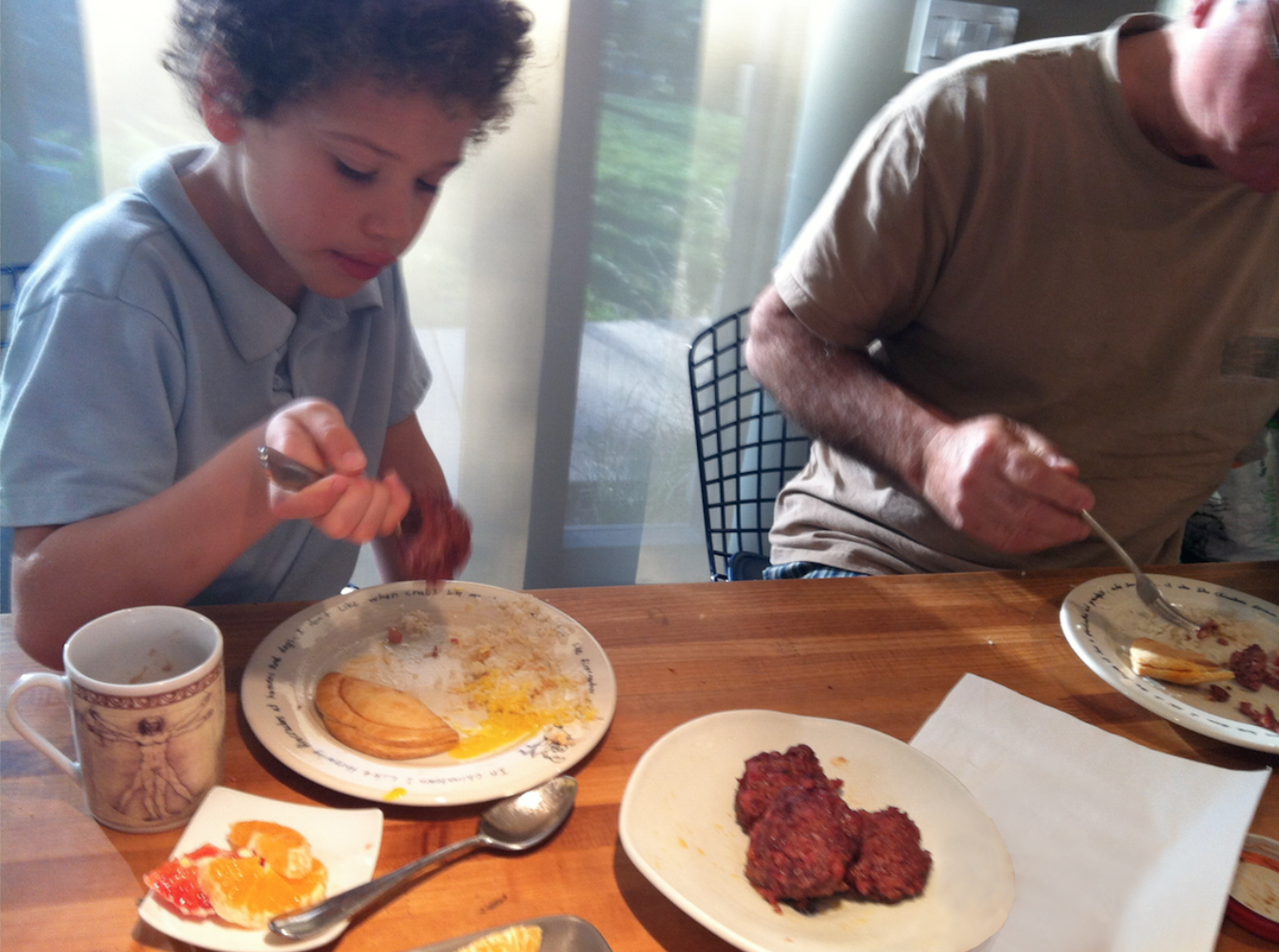 Older brother Anthony set the tone for eating with enjoyment. Breakfast with grandpa; home-made sausages in the foreground. Chinatown plates by Steve Wong. 