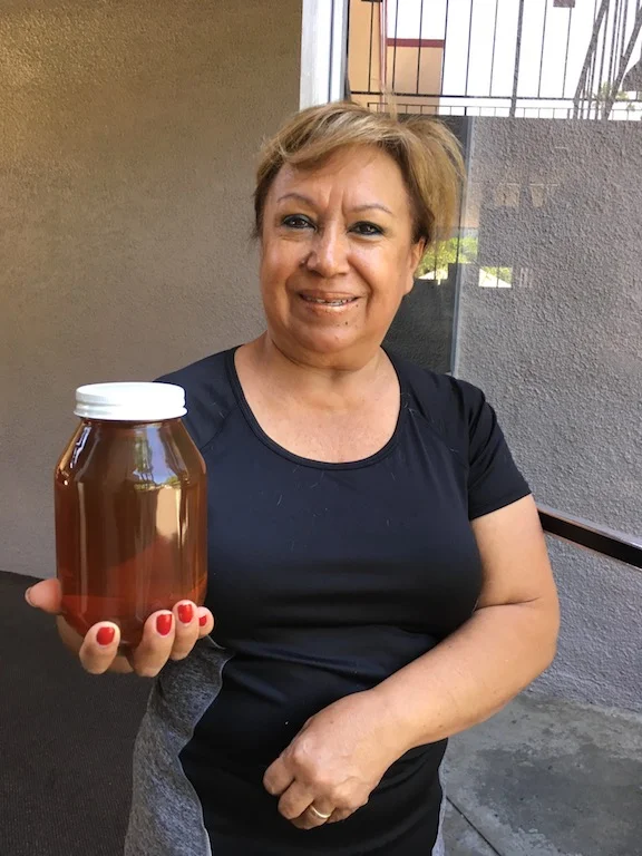 Martha holding a jar of her father-in-law Victor Jaramillo's honey. 