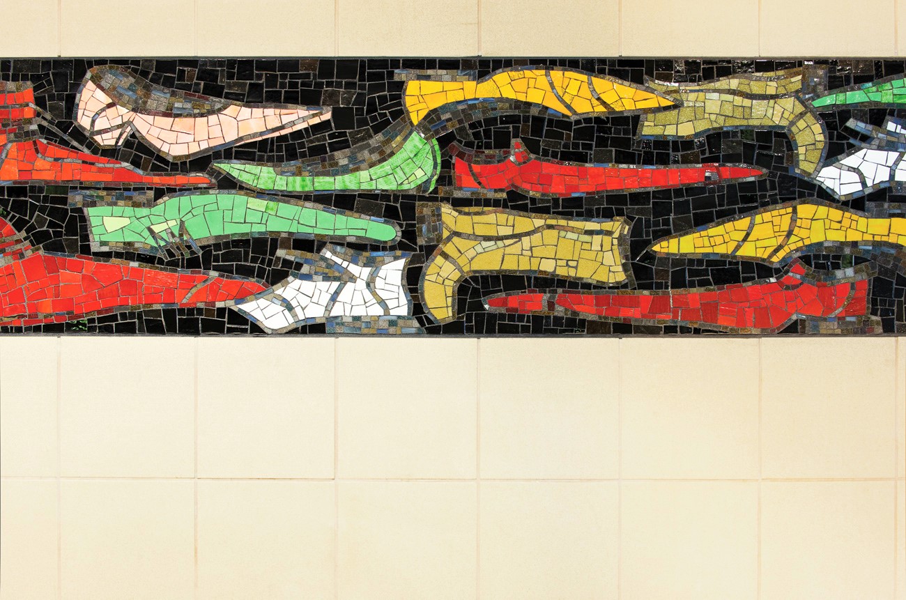 Made of smalti and cake glass, the 2 foot by 115 foot mosaic band wraps across three walls at the station mezzanine entry and was created by artisans at the Miotto Mosaic Art Studio in Carmel, NY.