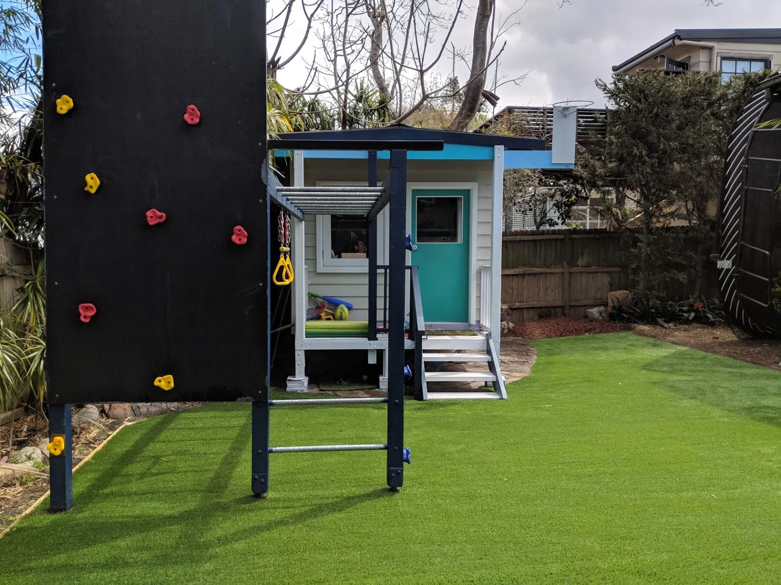 This area didn’t grow grass very well and was either dusty or muddy. Premium synthetic grass was used to give a great space for the children to play in.