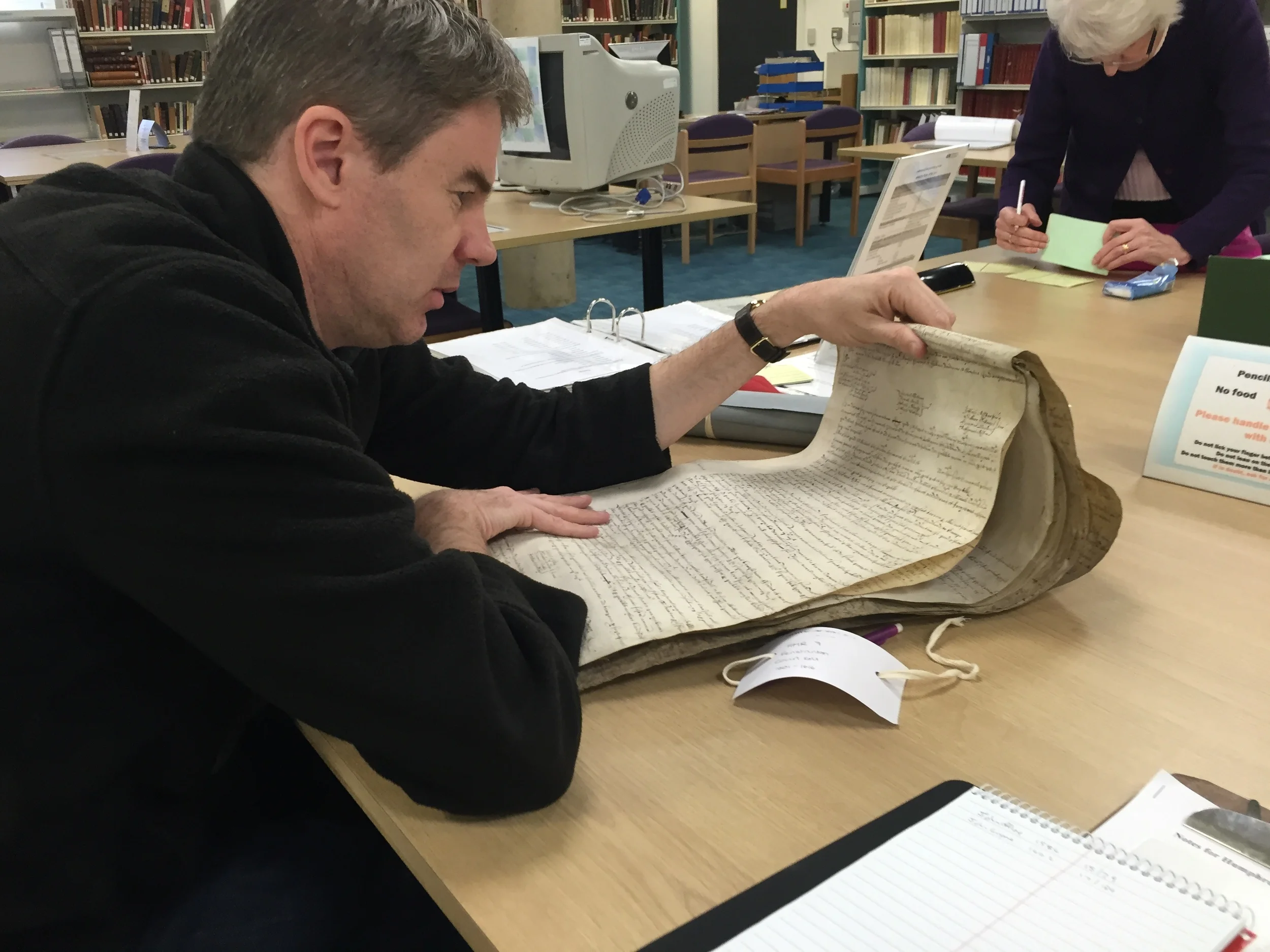 Reviewing a 1614 manorial court roll for the parish of Fenstanton, at the Huntingdon Archives. This document was found to contain a reference to Henry Howland, the father of Mayflower passenger John Howland--a small fine for bringing a horse exhibiting signs of mange to the manor's common field. Photograph by Mayflower historian Caleb Johnson , and research commissioned by the Pilgrim John Howland Society .