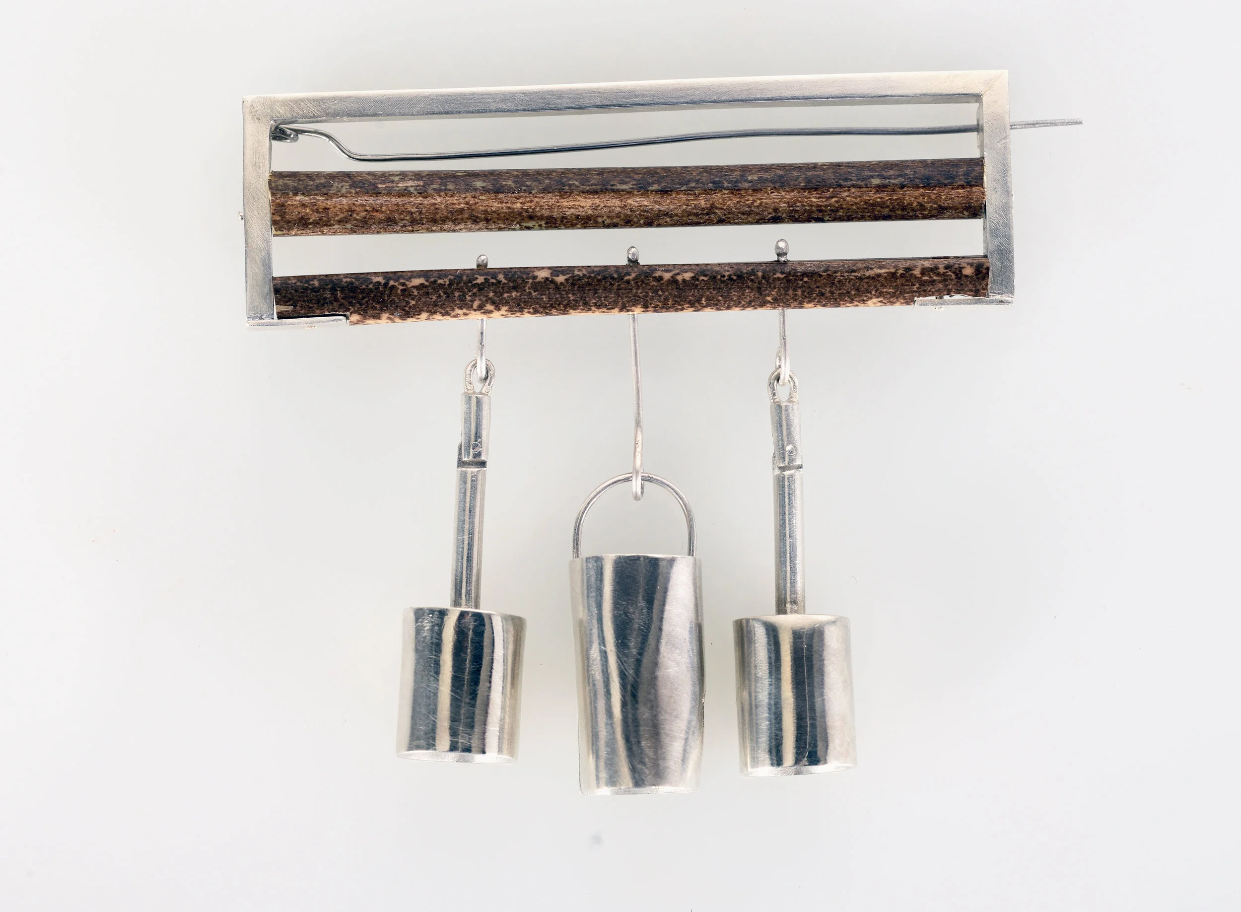 Elephant Bells II. Recycled Silver & Bamboo Brooch. The bamboo represents the logging industry and the silver bells represent the usually wooden bells which hand around the neck of an elephant when they are working the trekking trade. This is to alert tourists or workers when the elephant is near by. I decieded to replicate these in Silver. 