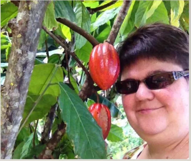 Romi Burks beside a Theobroma Cacao tree 