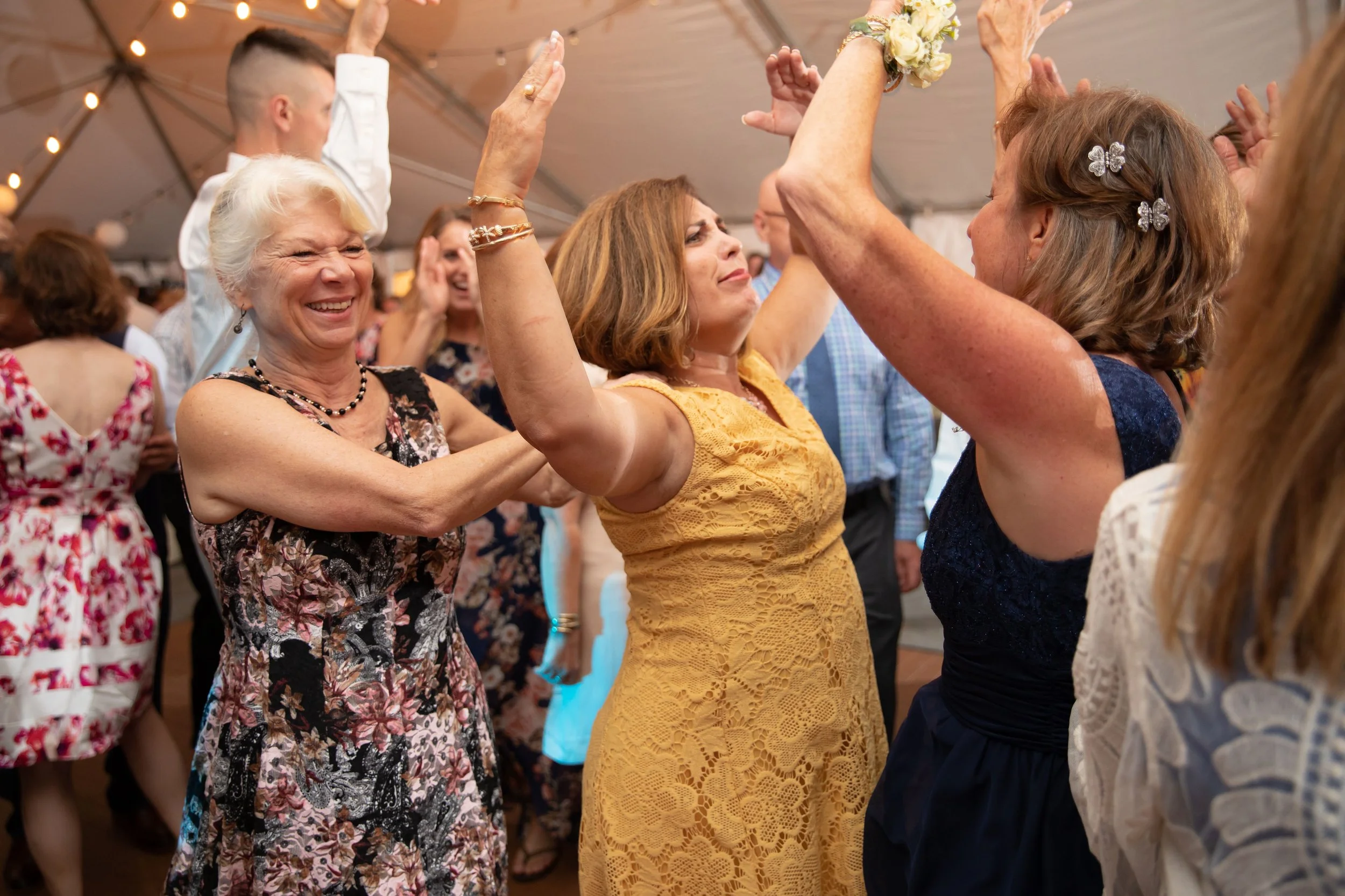 People dancing closely together at a lively event, smiling and enjoying themselves.