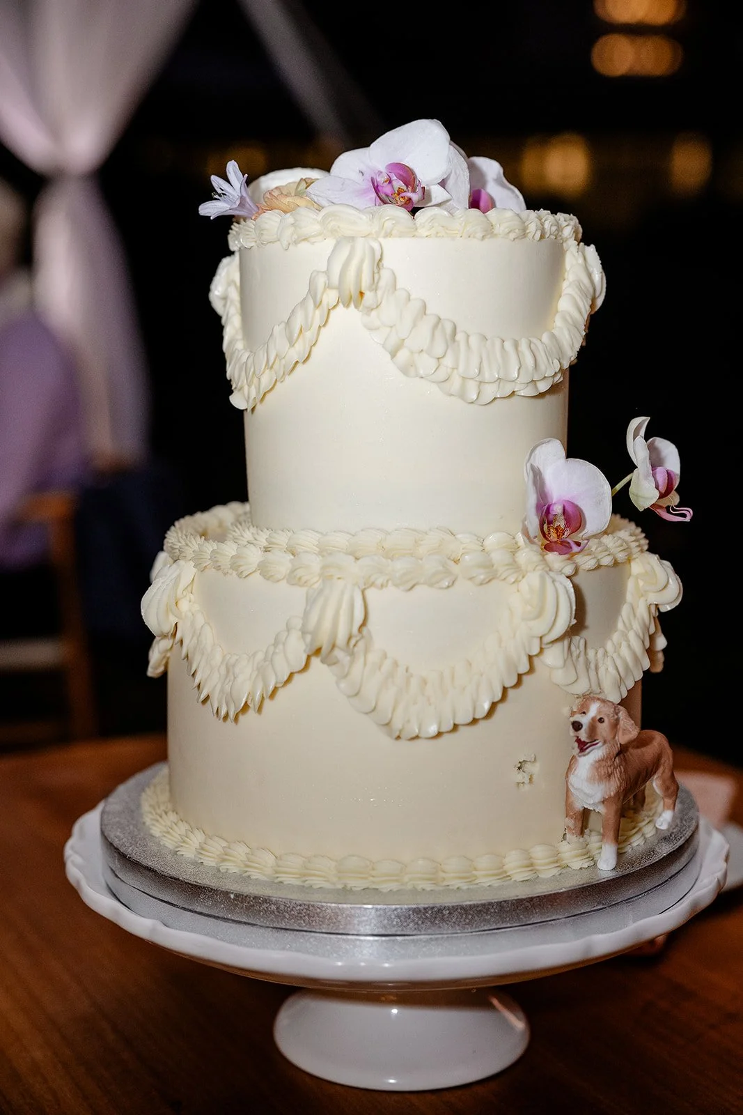 wedding cake with purple flowers and dog figurine