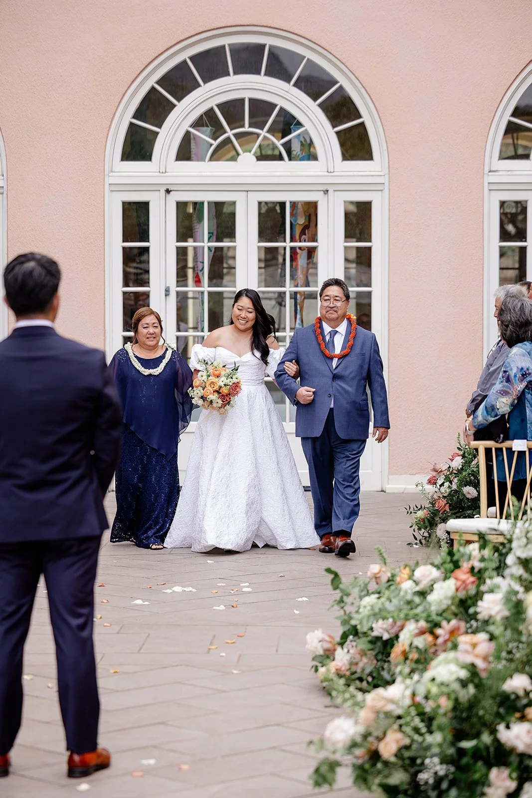 bride walking down the aisle with parents