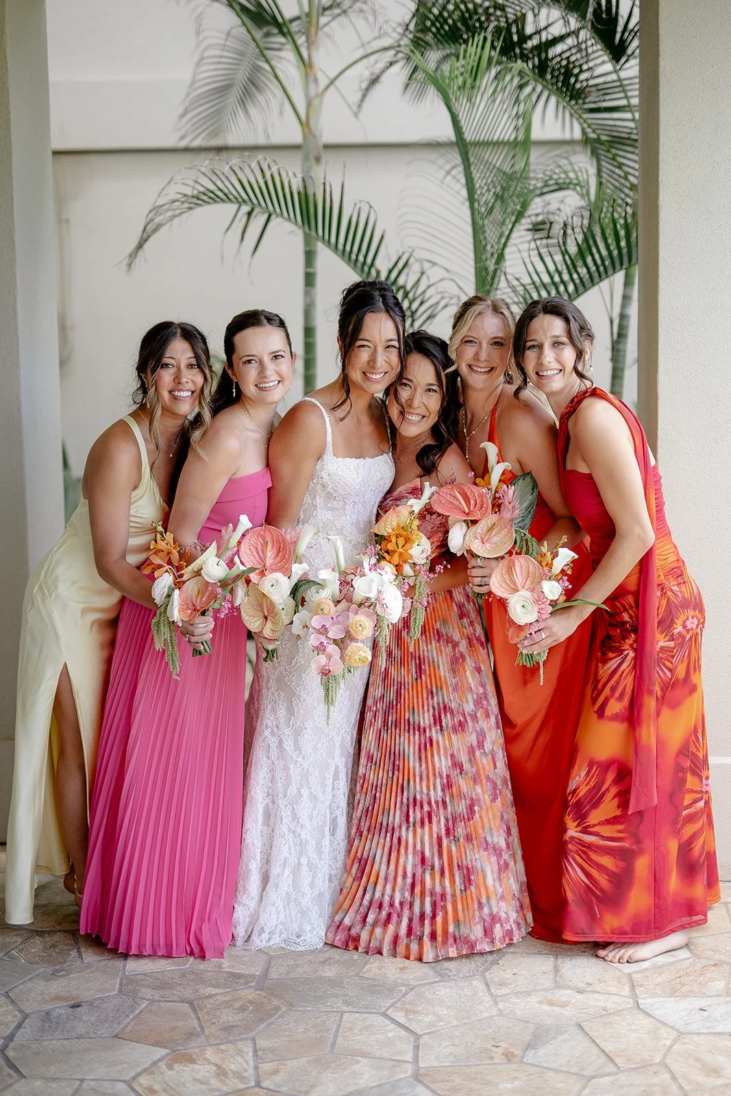bride with bridesmaids in sunset color dresses