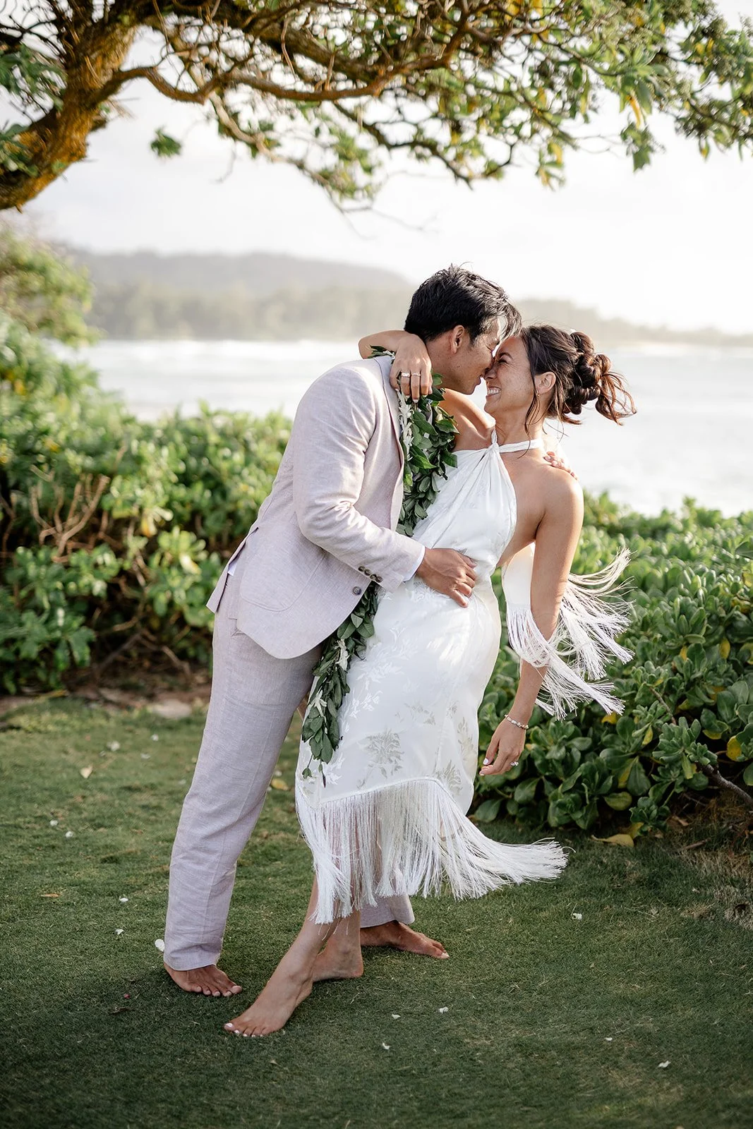 groom dipping bride near the ocean in hawaii