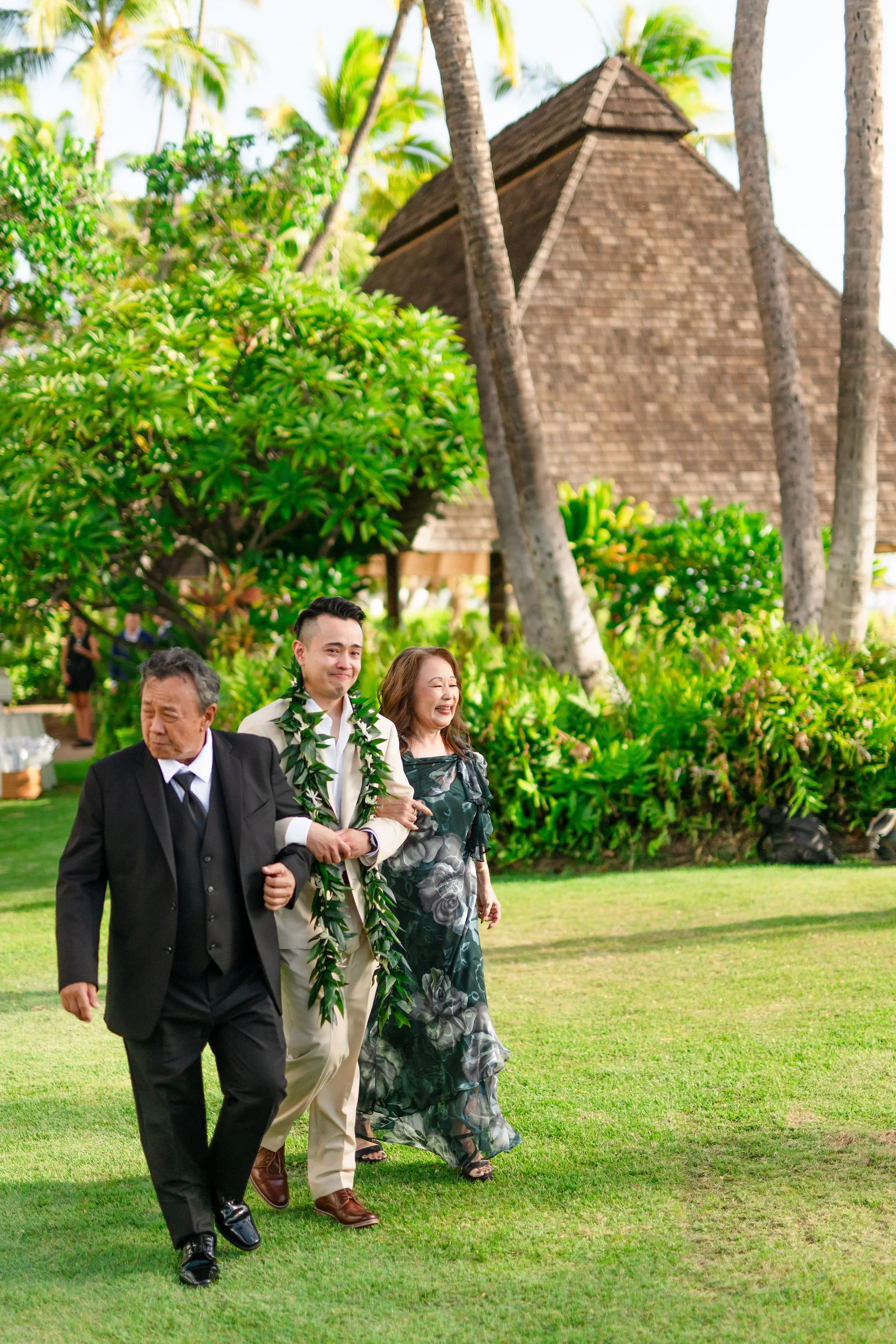 groom walking down aisle with parents