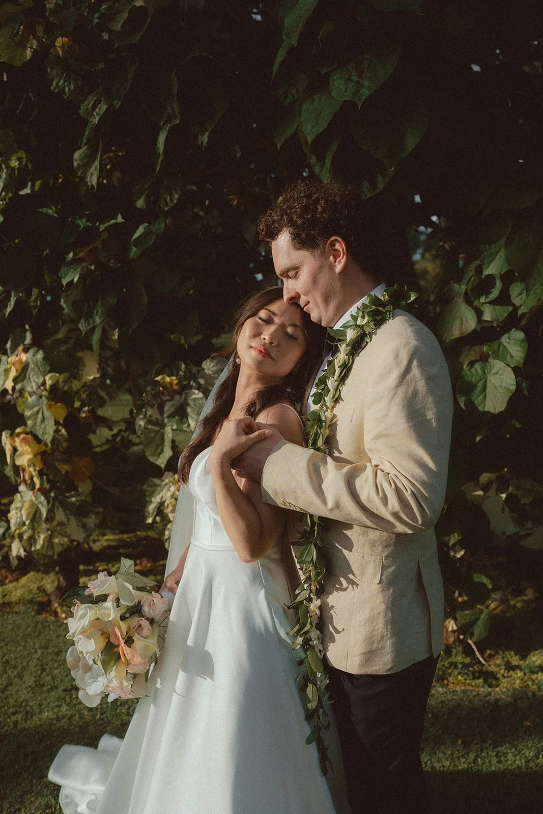 bride and groom by greenery