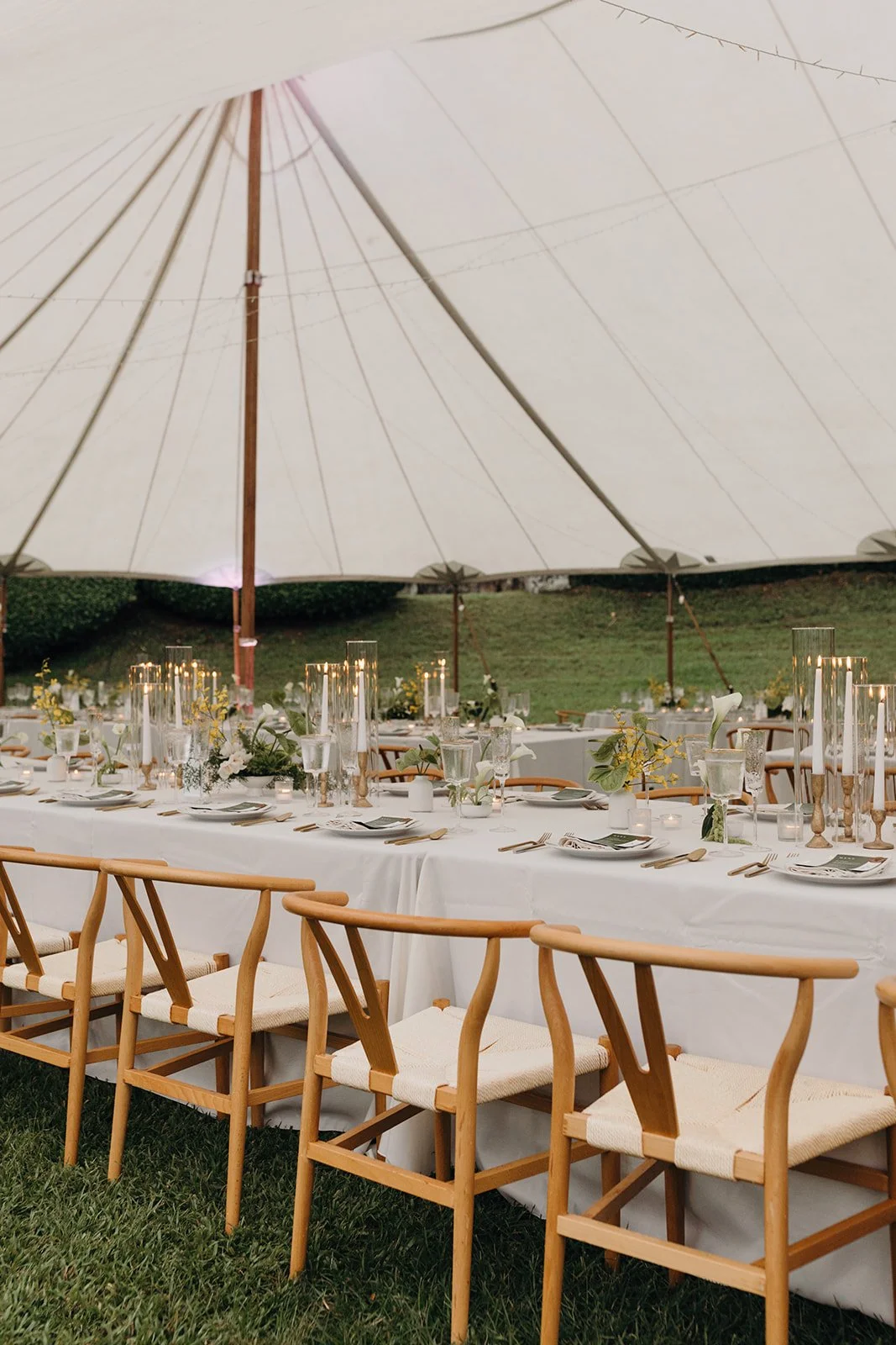 white wedding table with green and yellow florals and gold candles