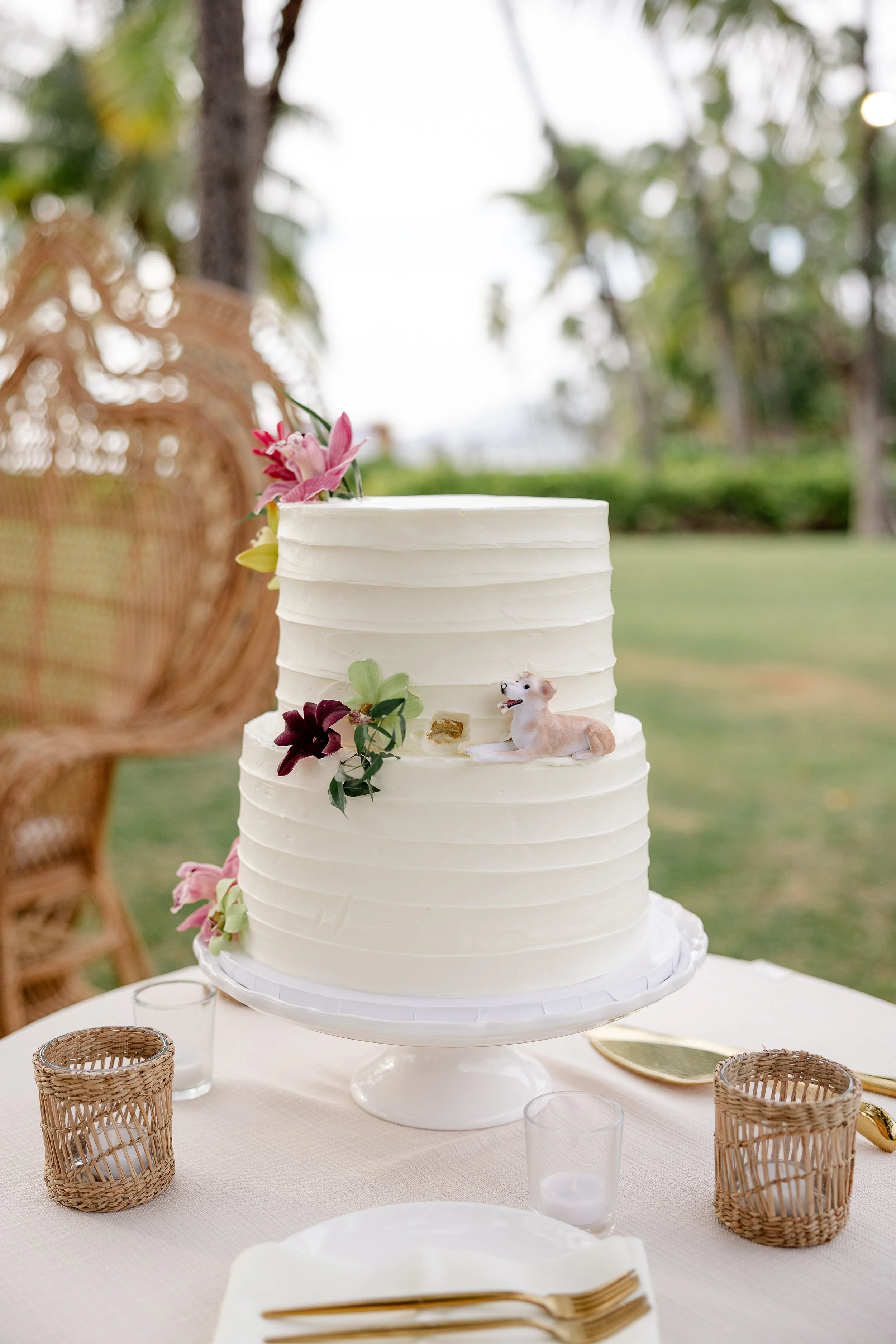wedding cake with tropical flowers and dog figurine